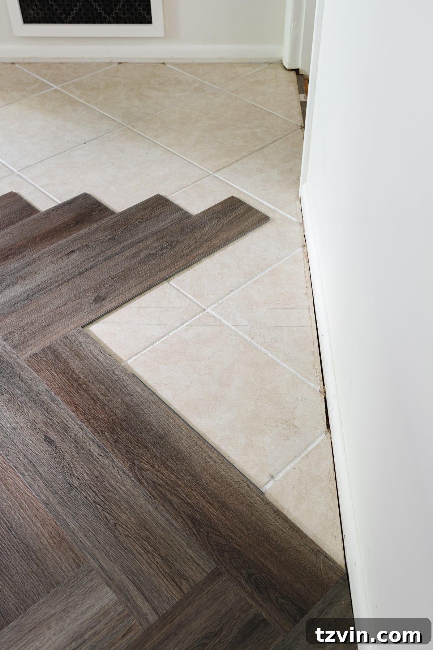 finishing a row of herringbone LVP flooring against a wall