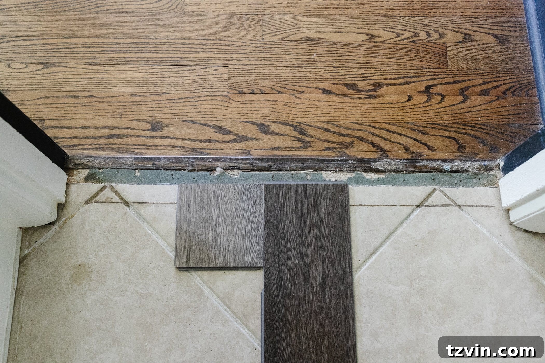 Light beige and dark brown herringbone LVP floor samples on top of beige tile 