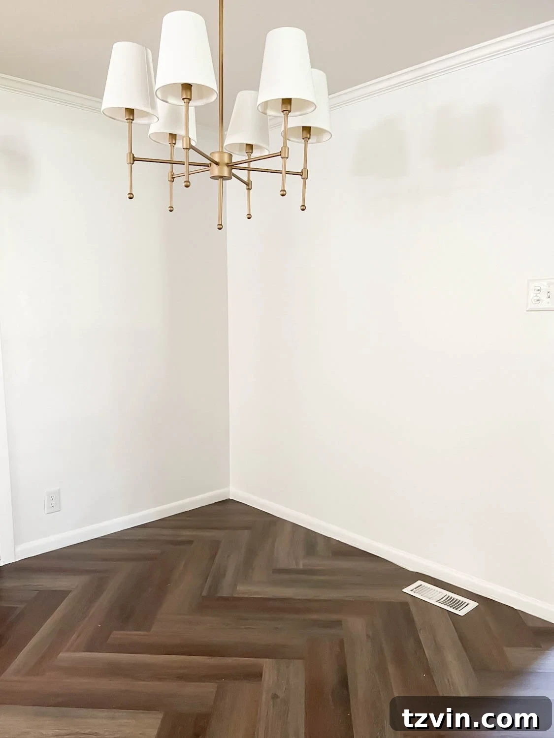 corner of breakfast nook with chandelier, white walls, and herringbone floor with a floor vent