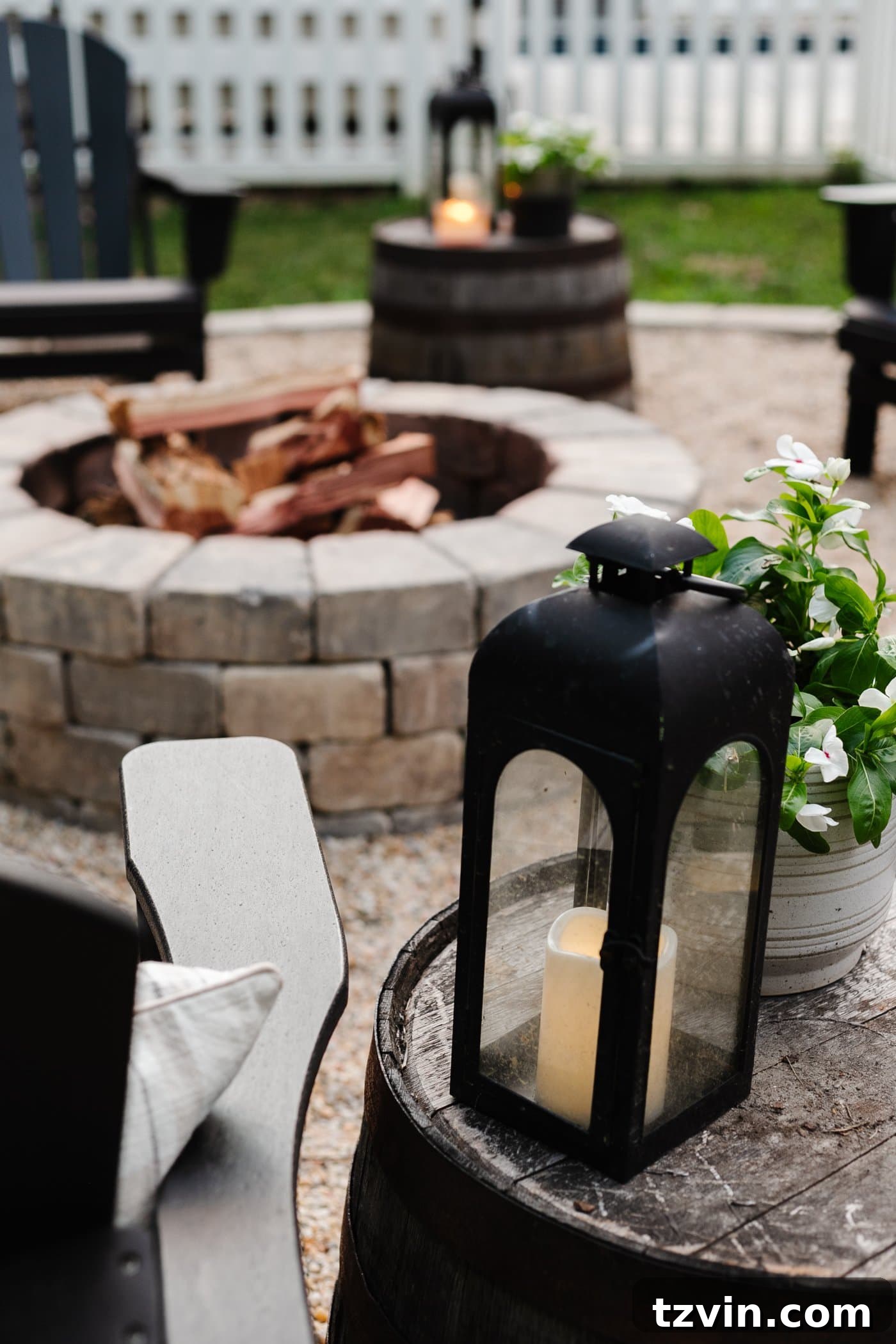 Illuminate Your Nights: Simple DIY Backyard Lighting Projects 12 a classic black lantern placed beside an Adirondack chair at a backyard fire pit, creating cozy ambiance