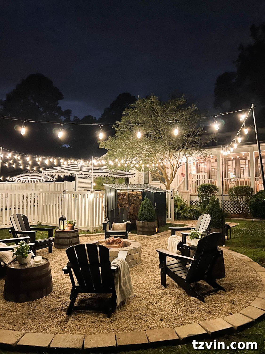 Illuminate Your Nights: Simple DIY Backyard Lighting Projects 14 a charming fire pit area with string lights, pea gravel, black Adirondack chairs, and a rustic wood shed in a backyard