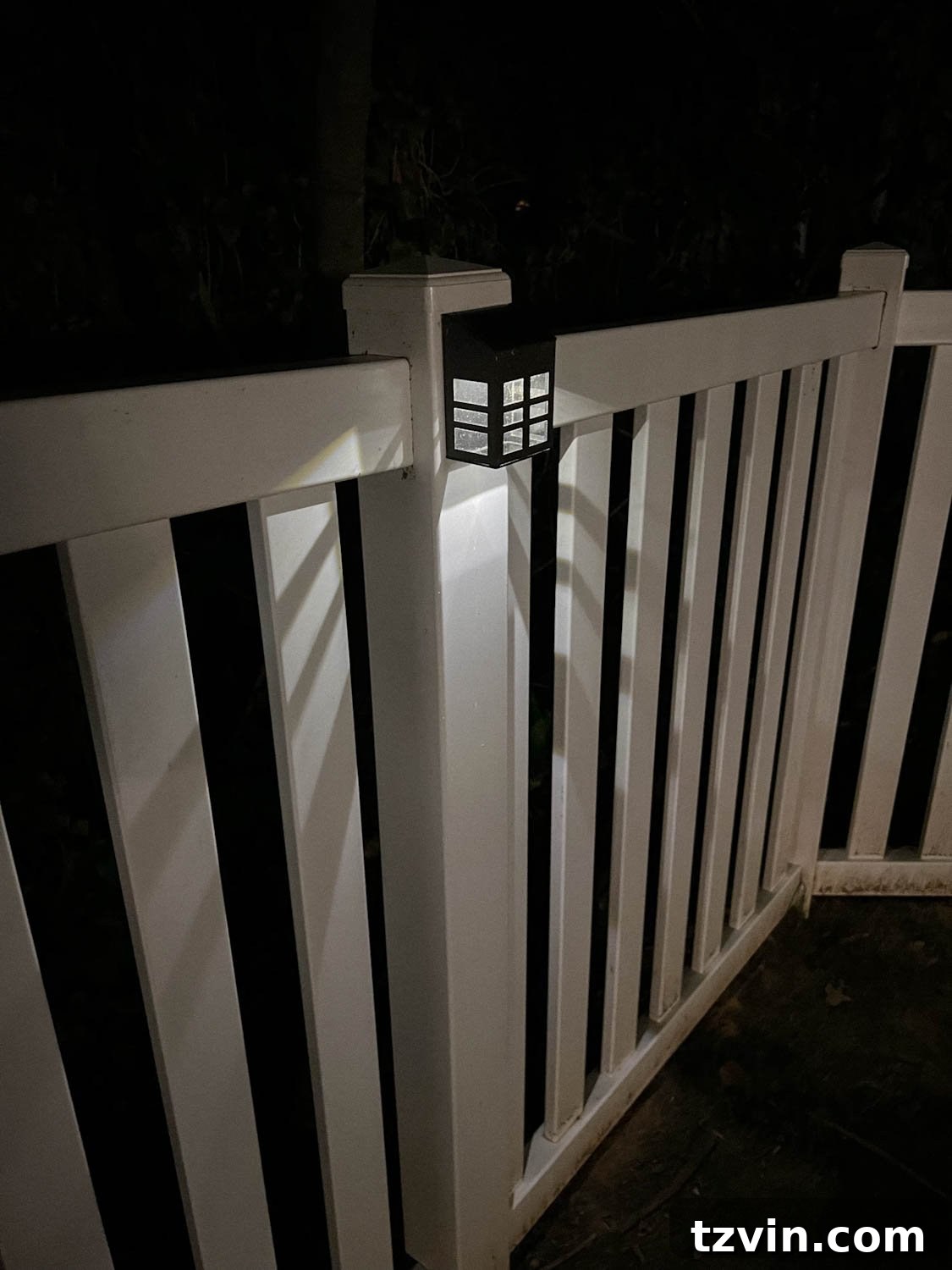 Illuminate Your Nights: Simple DIY Backyard Lighting Projects 10 a solar step light attached to a wooden fence post, providing a soft glow at night