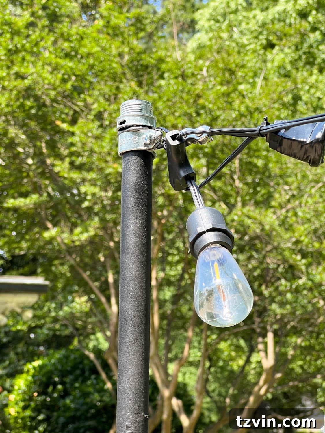 Creative String Light Solutions for Every Backyard Corner 25 string lights attached to poles with squeeze connectors screwed to cable