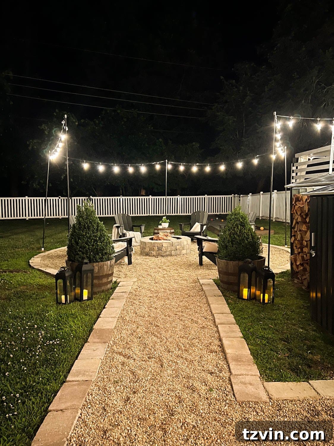 Creative String Light Solutions for Every Backyard Corner 29 hanging string lights around a fire pit with poles at night