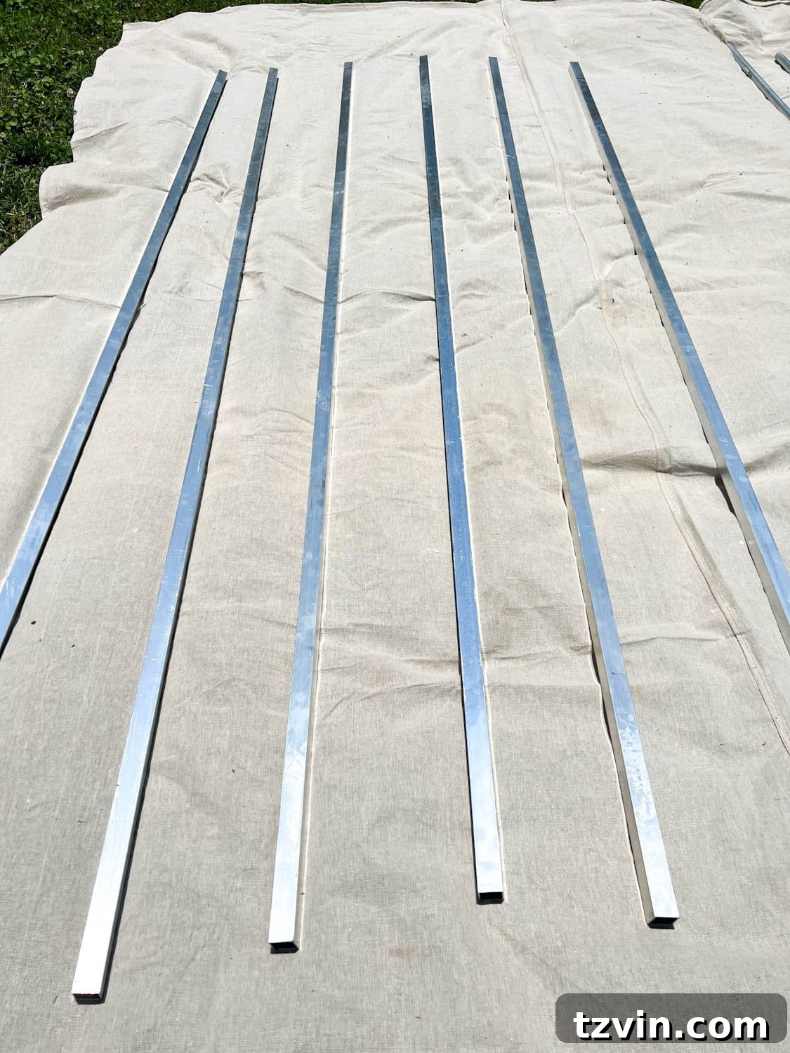Creative String Light Solutions for Every Backyard Corner 32 square aluminum tubing on a drop cloth to be painted
