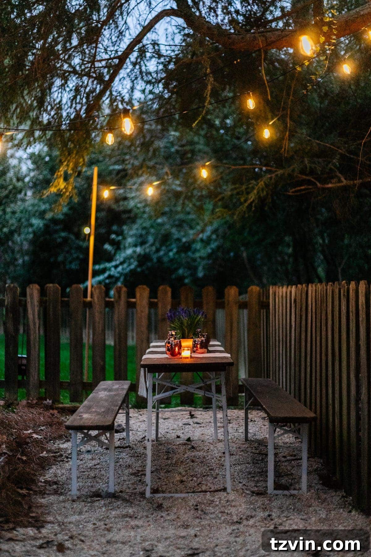 Creative String Light Solutions for Every Backyard Corner 50 solar lights hanging from a tree above an outdoor table