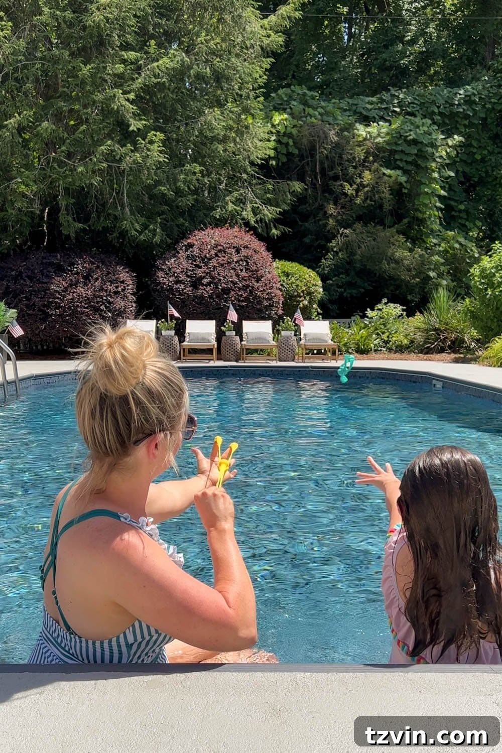 mother and daughter playing with swimming pool toys in a backyard