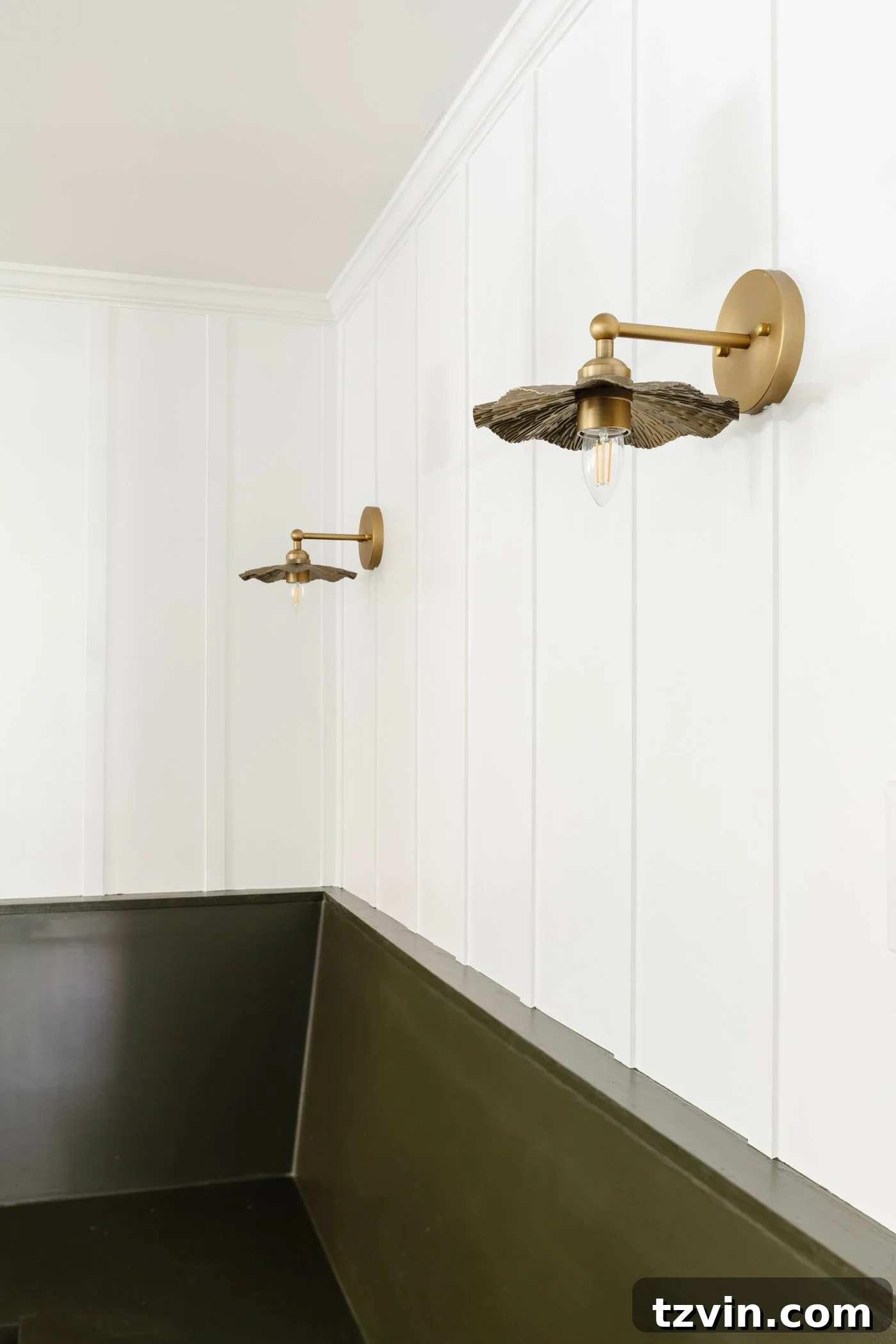 Create a Budget Batten Wall with Lattice Strips 11 A beautifully painted white batten wall, crafted with lattice strips, featuring elegant brass vintage-style sconces and a cozy green banquette
