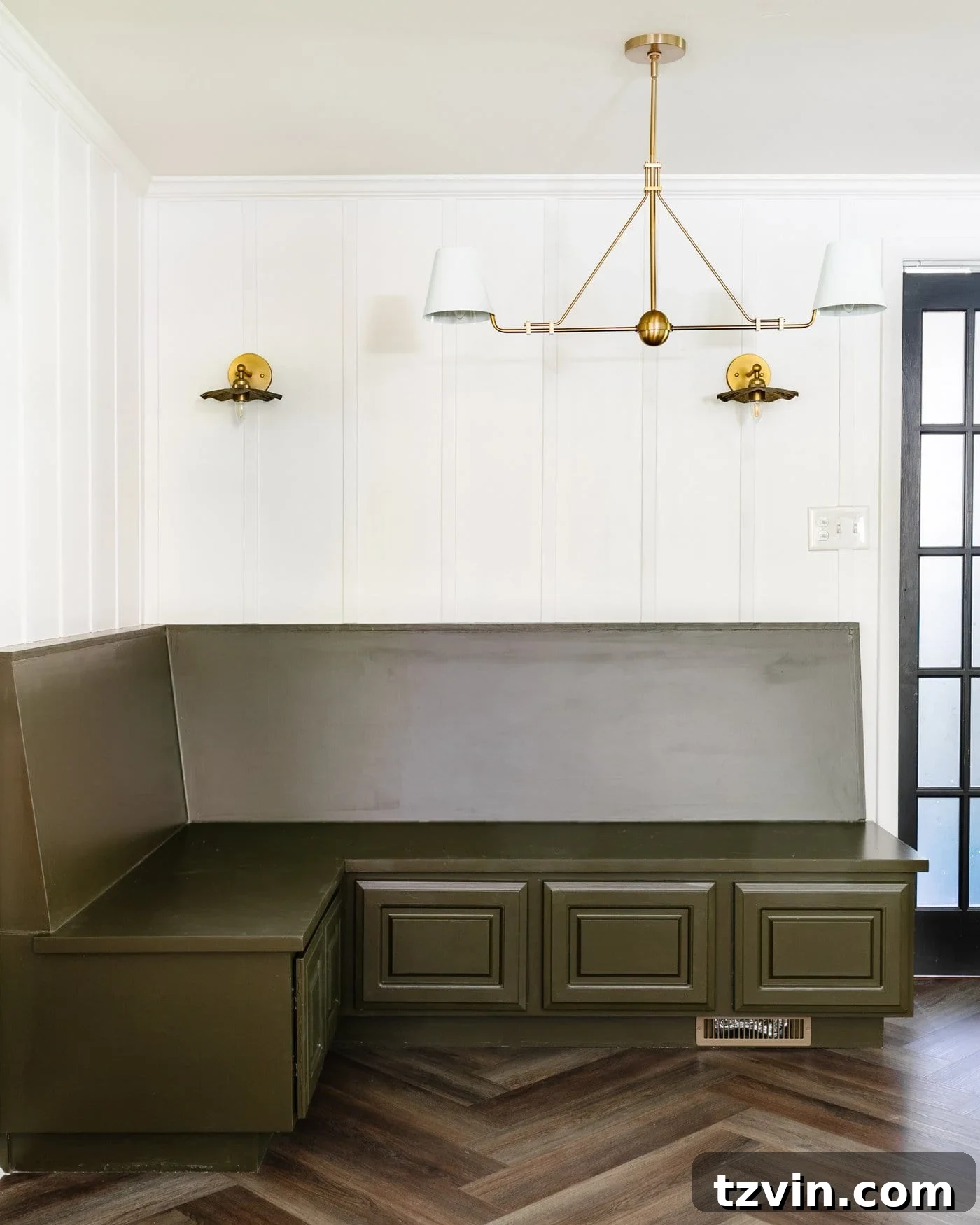 Create a Budget Batten Wall with Lattice Strips 12 A cozy breakfast nook featuring an olive green banquette bench, pristine white batten wall made of lattice strips, and elegant brass lighting fixtures, all set against classic herringbone floors