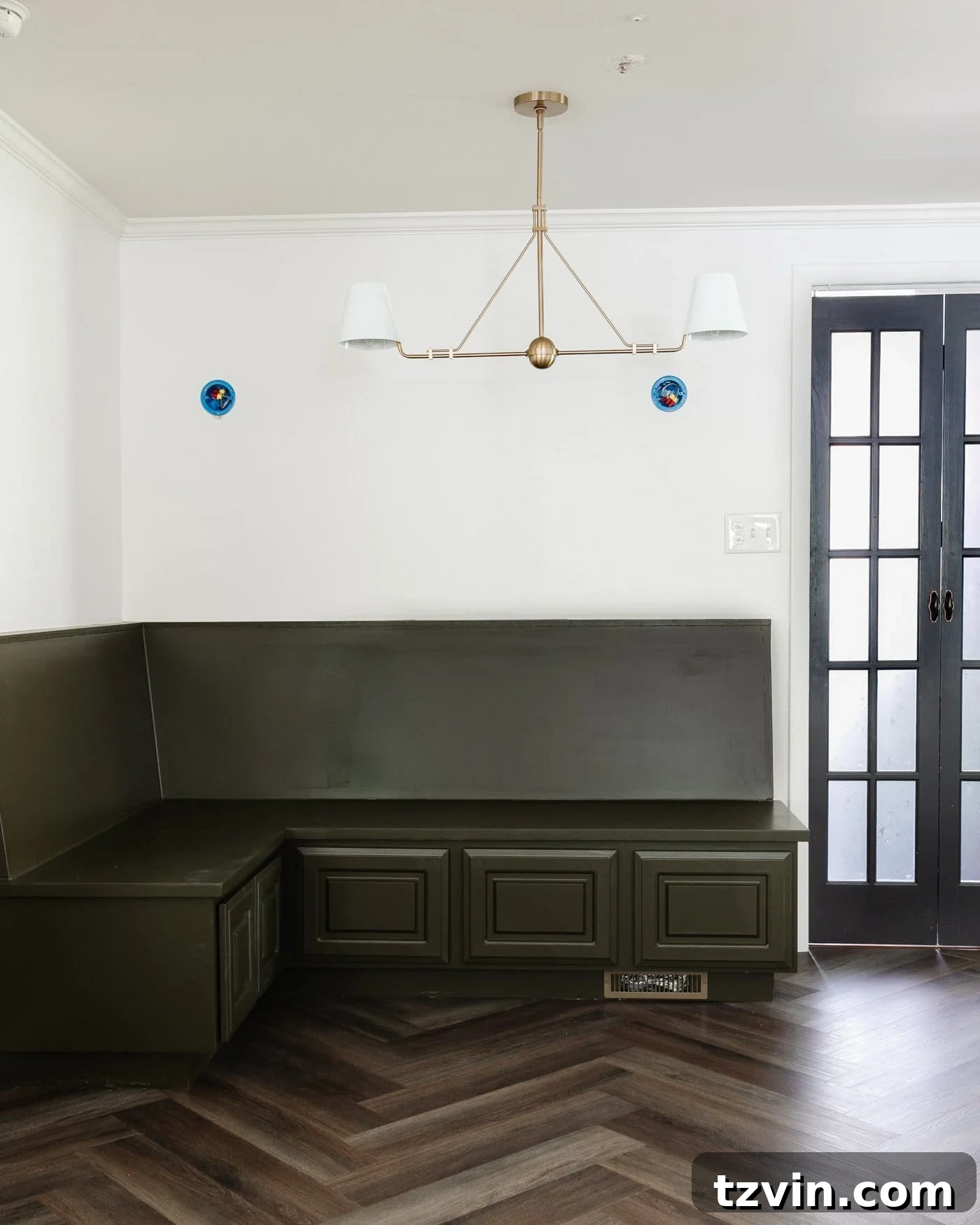 Create a Budget Batten Wall with Lattice Strips 3 A charming breakfast nook featuring an olive green banquette, classic herringbone floors, pristine white batten walls, and elegant black bifold French doors
