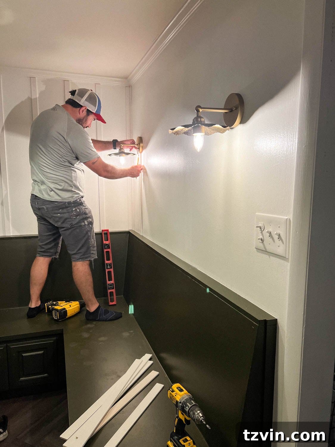 Create a Budget Batten Wall with Lattice Strips 7 A person dry fitting and installing lattice strips on a wall for a DIY batten wall molding project