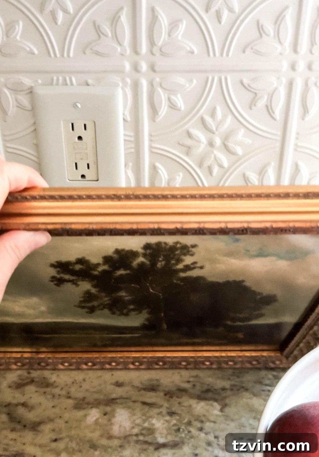hiding a kitchen backsplash outlet with framed art