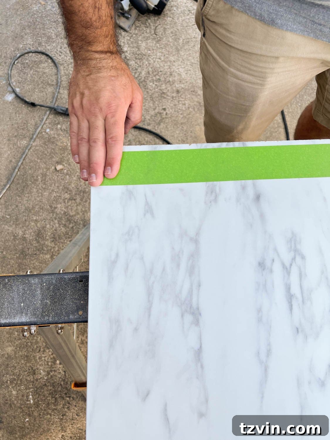 DIY Faux Marble Dining Table: Instant Luxury in Under an Hour 5 putting masking tape on laminate faux marble countertop to be cut, protecting the surface from chipping