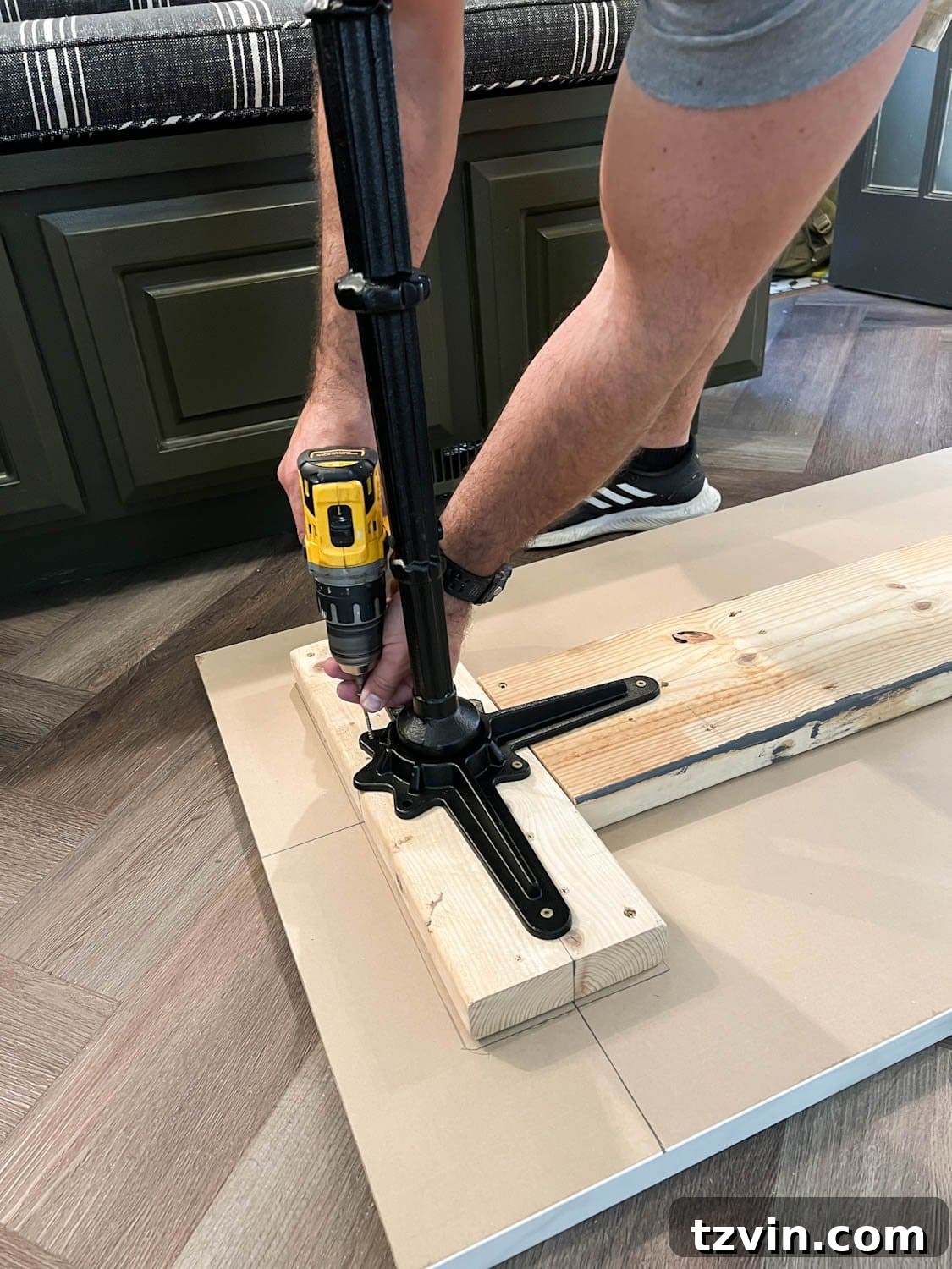 DIY Faux Marble Dining Table: Instant Luxury in Under an Hour 9 screwing cast iron pedestal table legs into a table top, demonstrating secure attachment