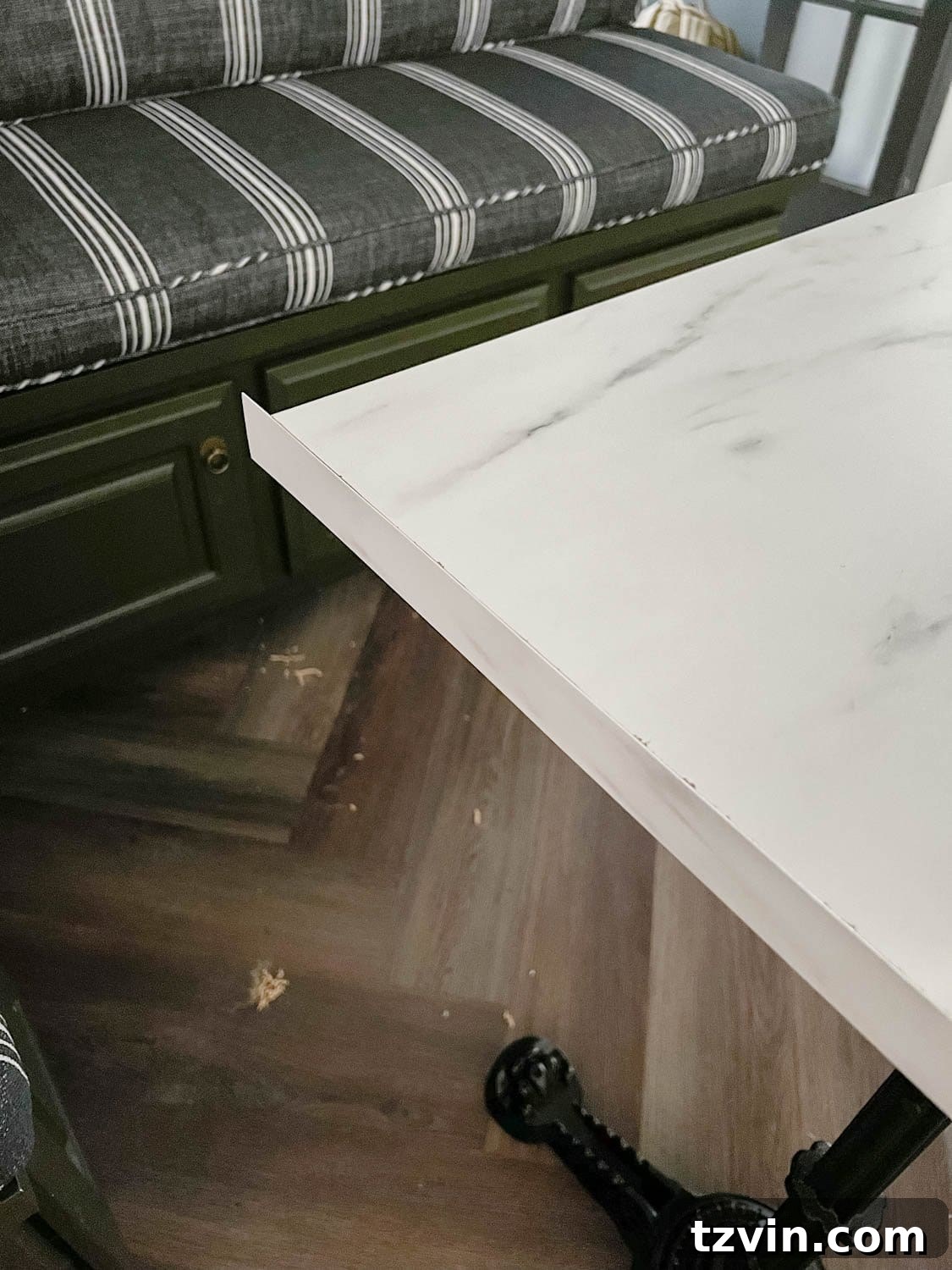 DIY Faux Marble Dining Table: Instant Luxury in Under an Hour 10 attaching laminate strip to a cut faux marble dining table top, showing the finishing touch