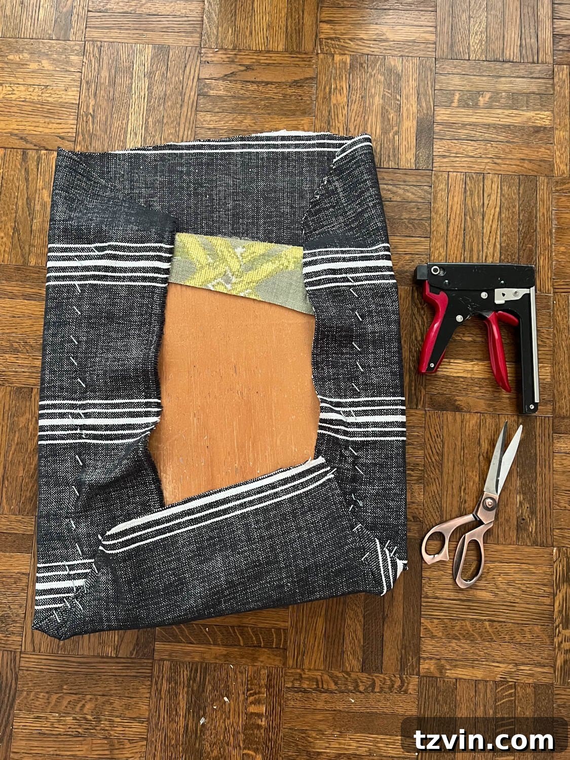 Revitalize Your Dining Chairs Seat Reupholstery and Faux Bamboo Transformation 6 three sides of covering a dining chair seat with upholstery fabric and a staple gun