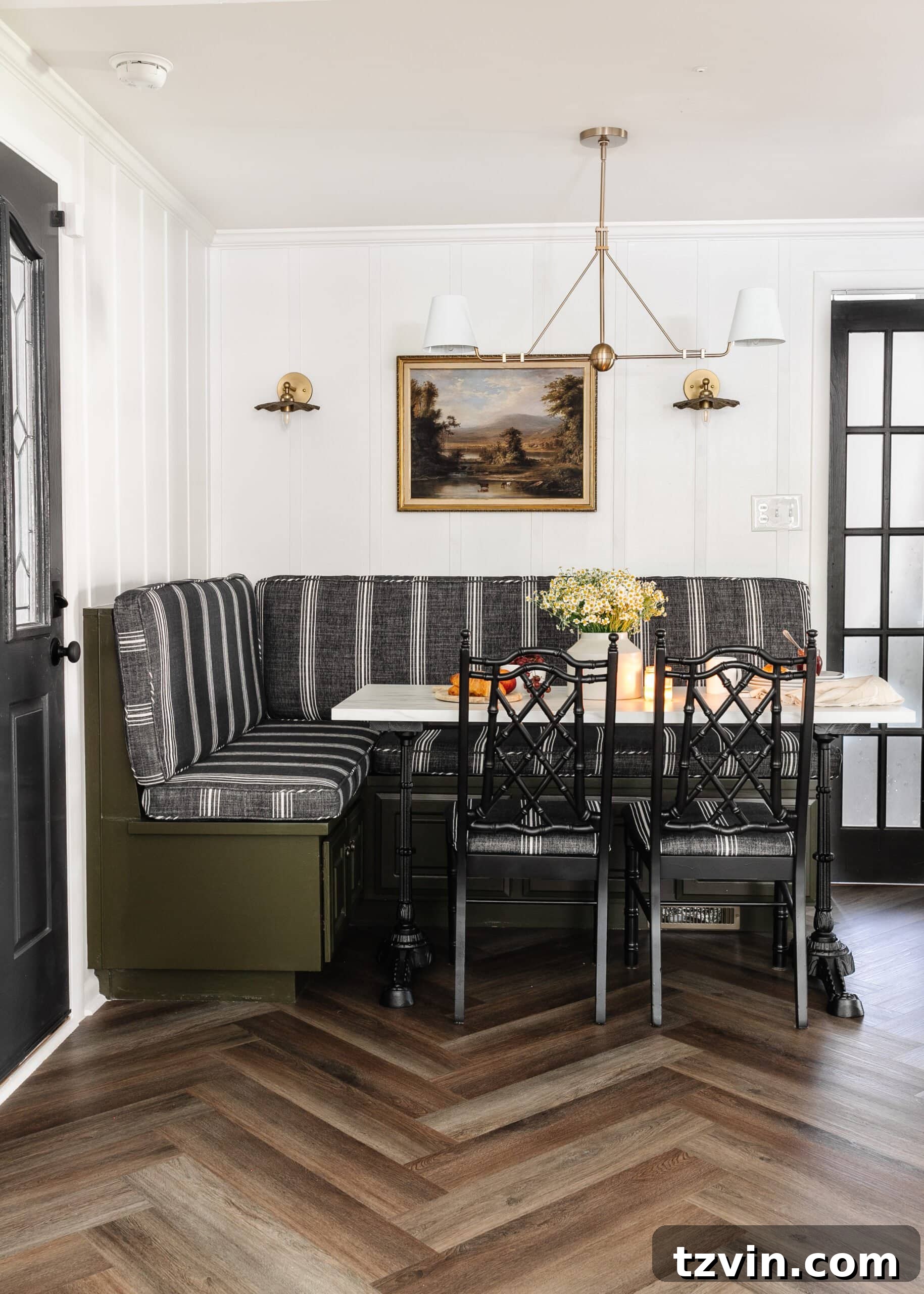 Chic Parisian Morning Retreat 17 Beautiful herringbone floors in a corner breakfast nook, featuring an olive green banquette bench, stylish black bamboo chairs, and a elegant marble table