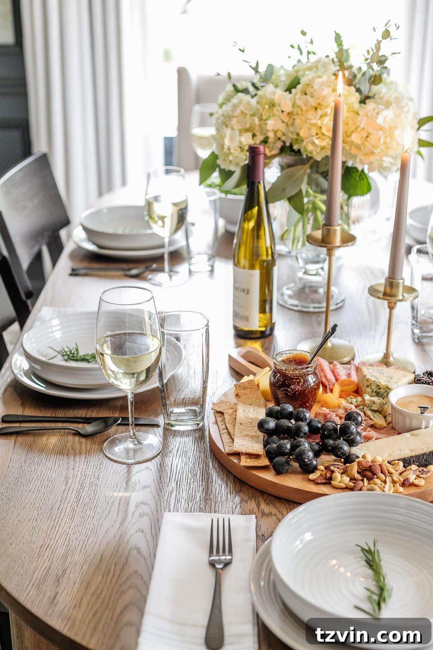 Effortless Table Settings for Every Occasion 17 dinner table decor with simple place setting, wine glasses, charcuterie board, candlesticks, and vase of flowers