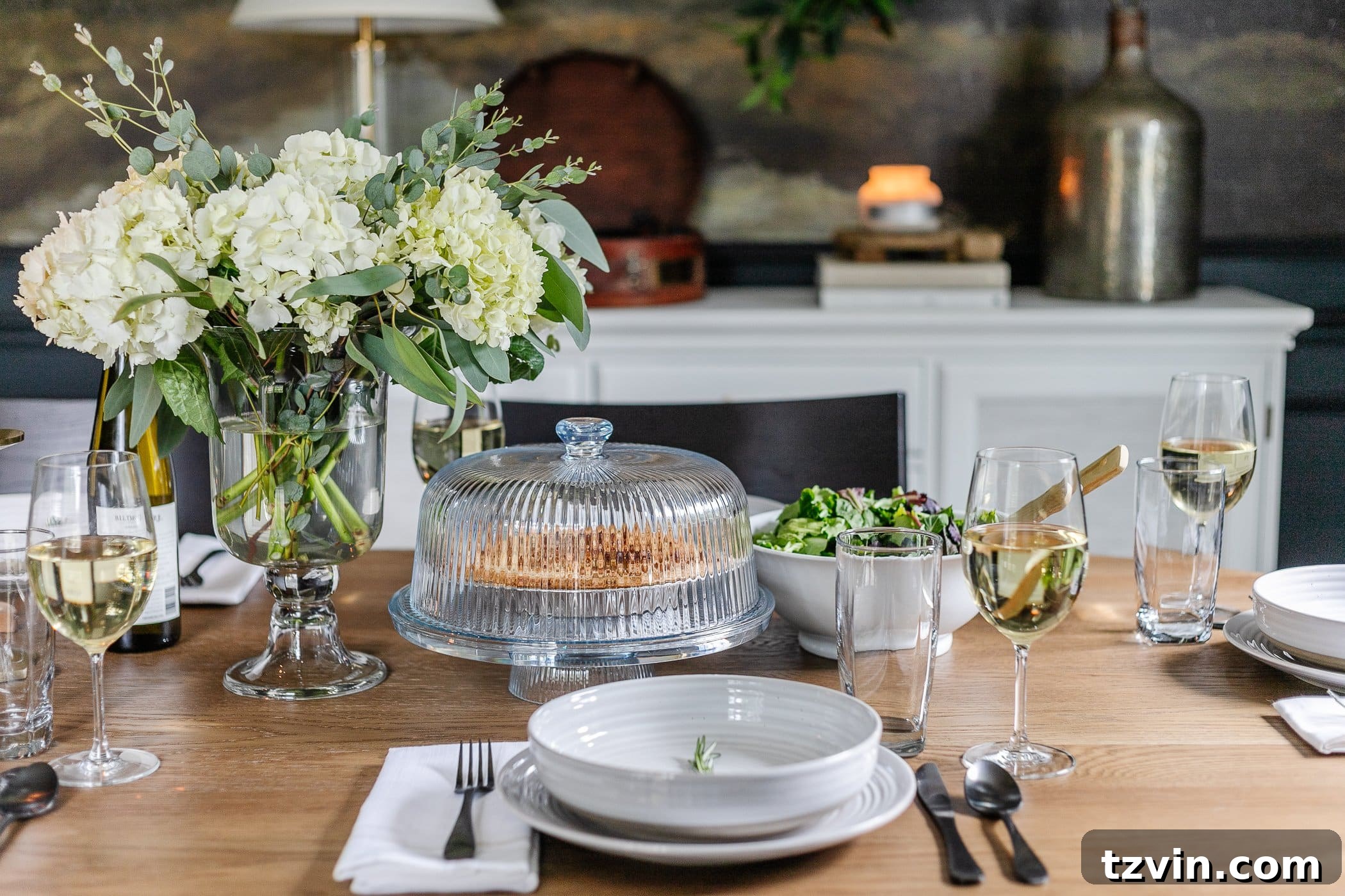 Effortless Table Settings for Every Occasion 8 vase of hydrangeas, simple place setting of gray dishes and sprig of rosemary, cake dome, and serving bowl of salad