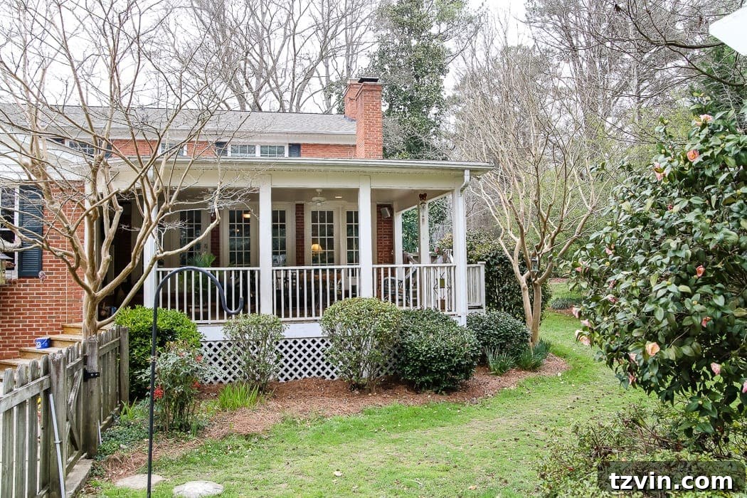 Before image of an orange brick house with its original back porch and overgrown backyard, awaiting a comprehensive transformation.