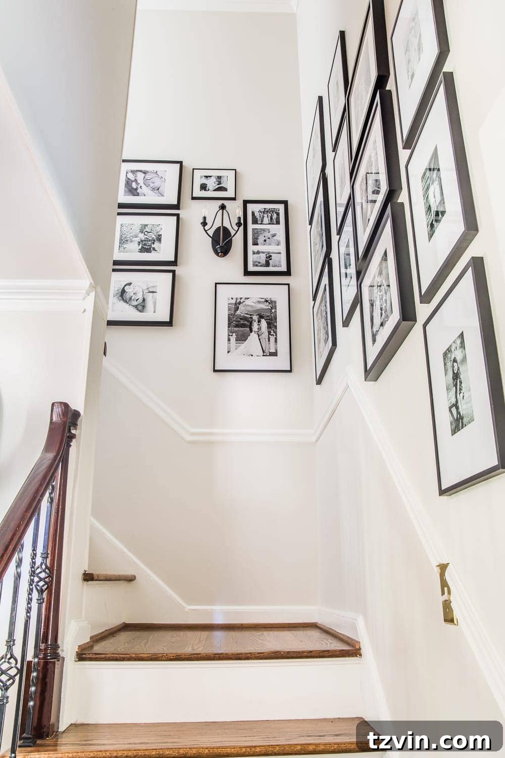 A tastefully arranged black and white family gallery wall adorning the staircase, featuring cherished memories in a cohesive display.
