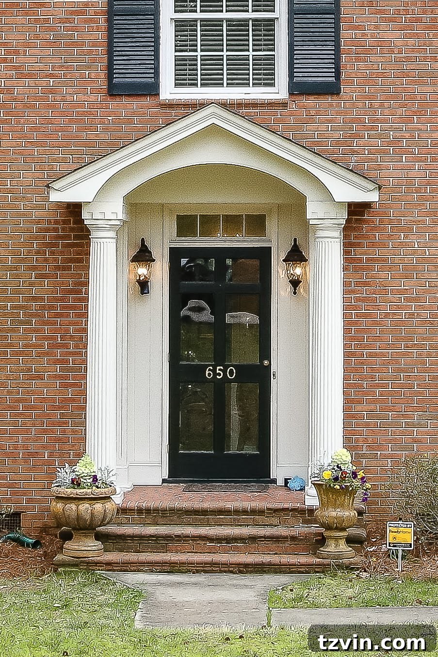 The original brick colonial house exterior before any renovation, featuring its traditional red brick facade.
