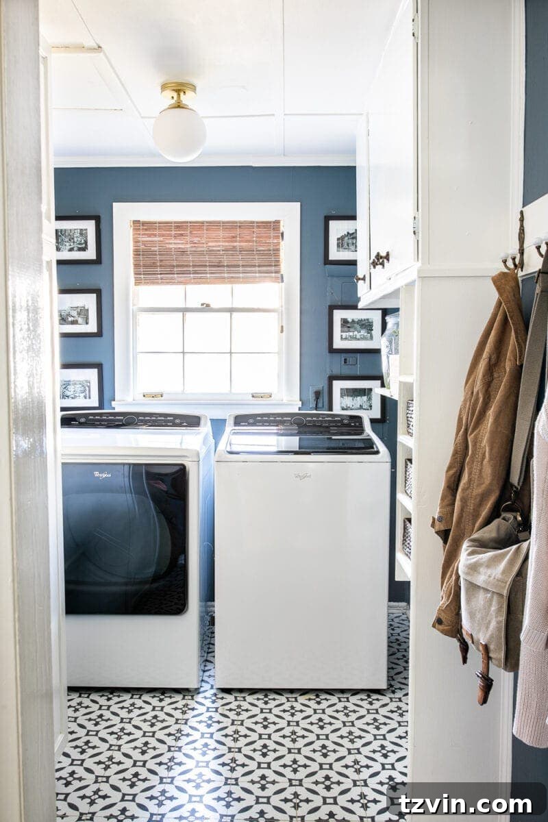 A vibrant navy blue laundry room featuring striking black and white Moroccan peel and stick tile floors, creating a stylish and functional space for chores.