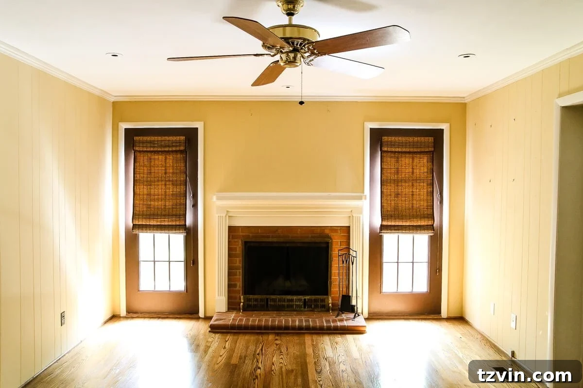 Before image of a yellow and white playroom with a prominent brick fireplace, awaiting a whimsical and organized transformation.