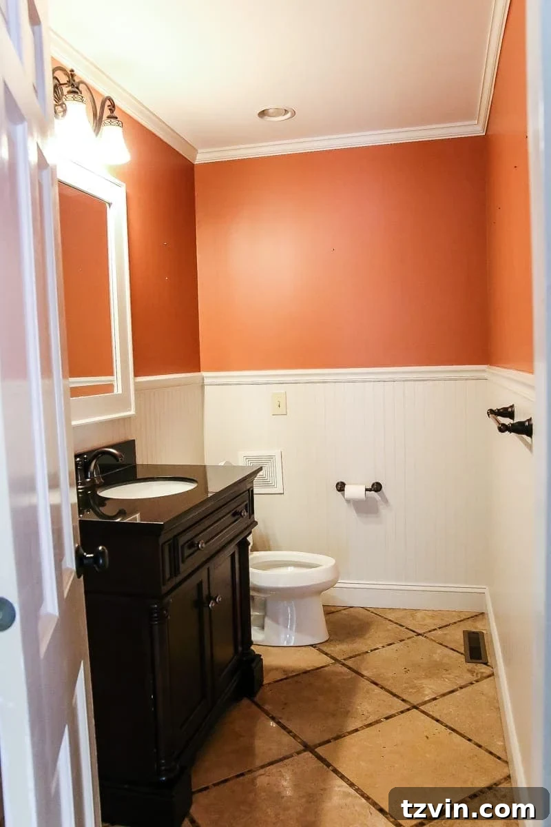 Before image of an orange half bath, a stark contrast to its upcoming refreshed and modern transformation.