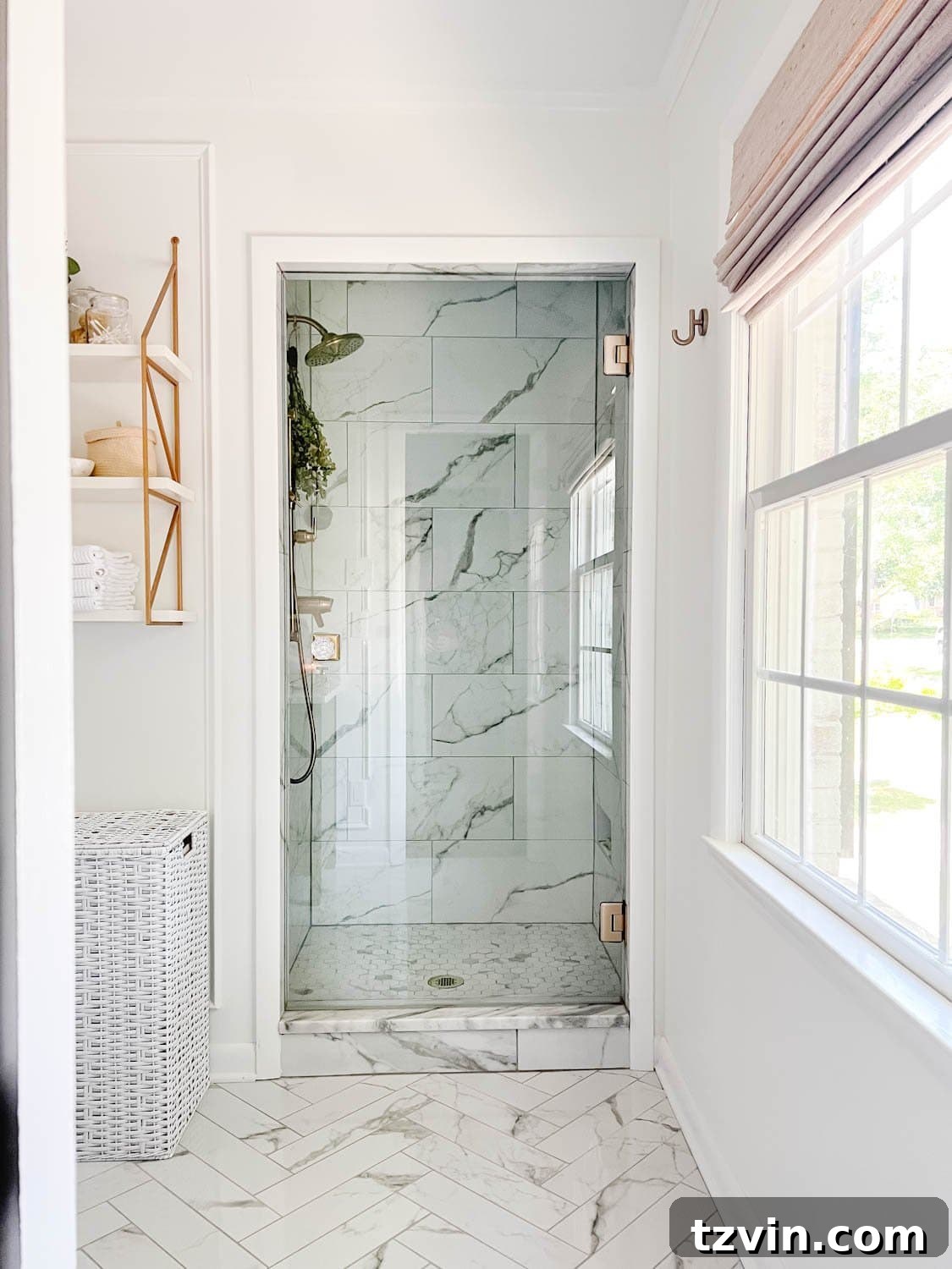 A bright white bathroom featuring a luxurious marble shower with a sleek frameless glass shower door, creating a sophisticated and spa-like ambiance.