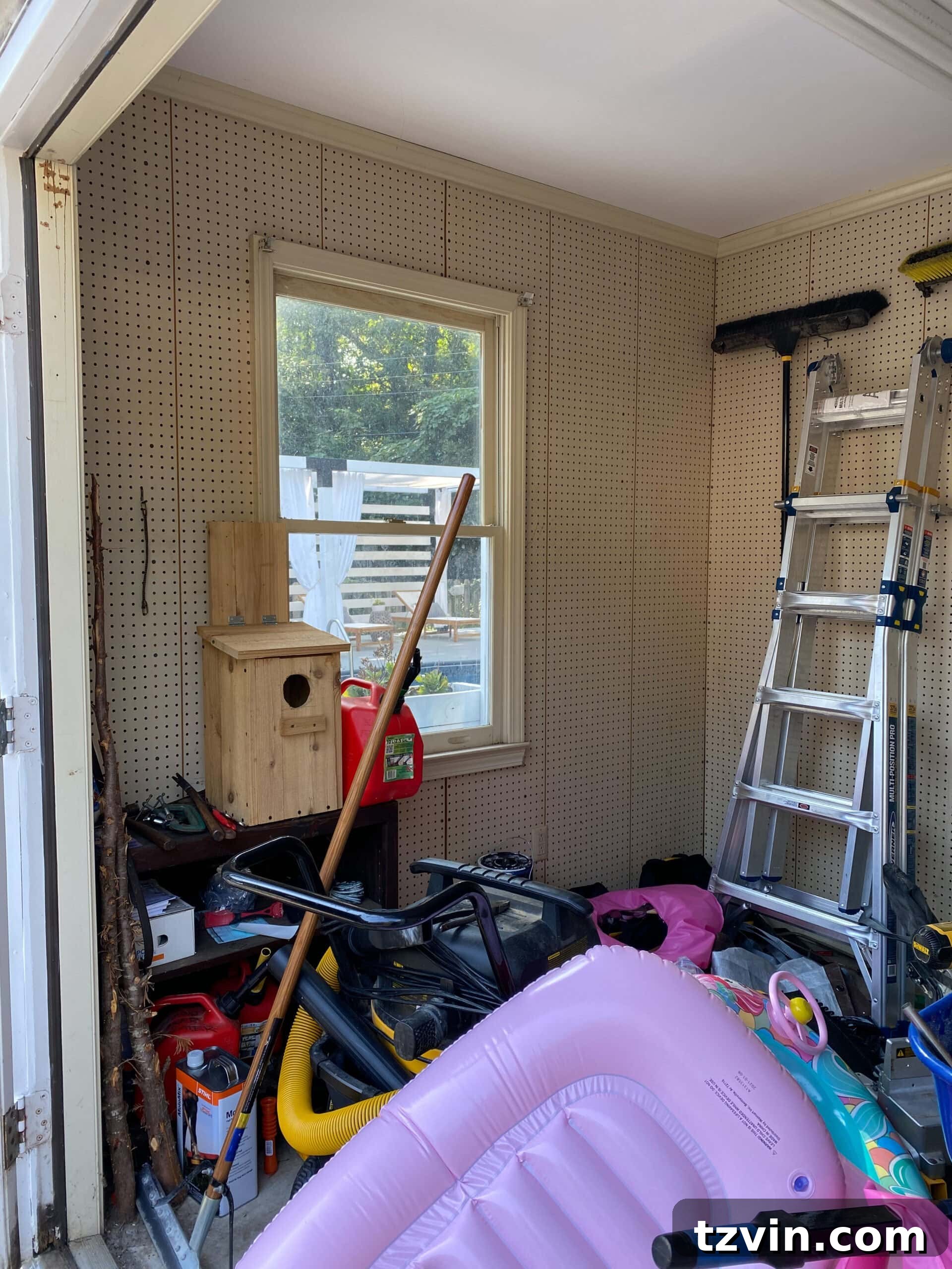 Before image of a backyard shed with a plain beige pegboard, awaiting a functional and stylish home gym transformation.