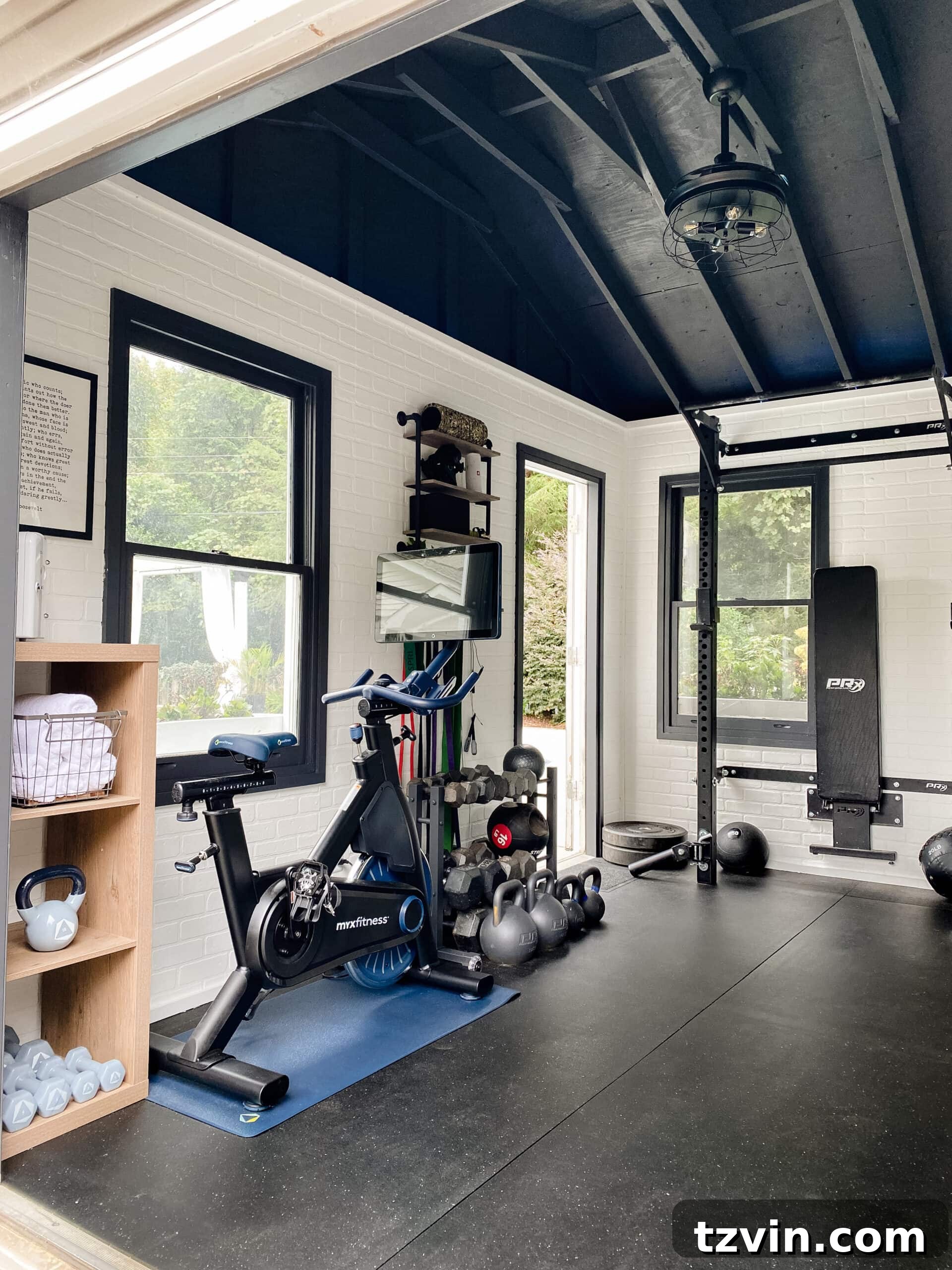 A functional home gym created from a backyard shed, featuring realistic faux brick walls, a dramatic black vaulted ceiling, and durable black rubber floors, designed for an effective workout experience.