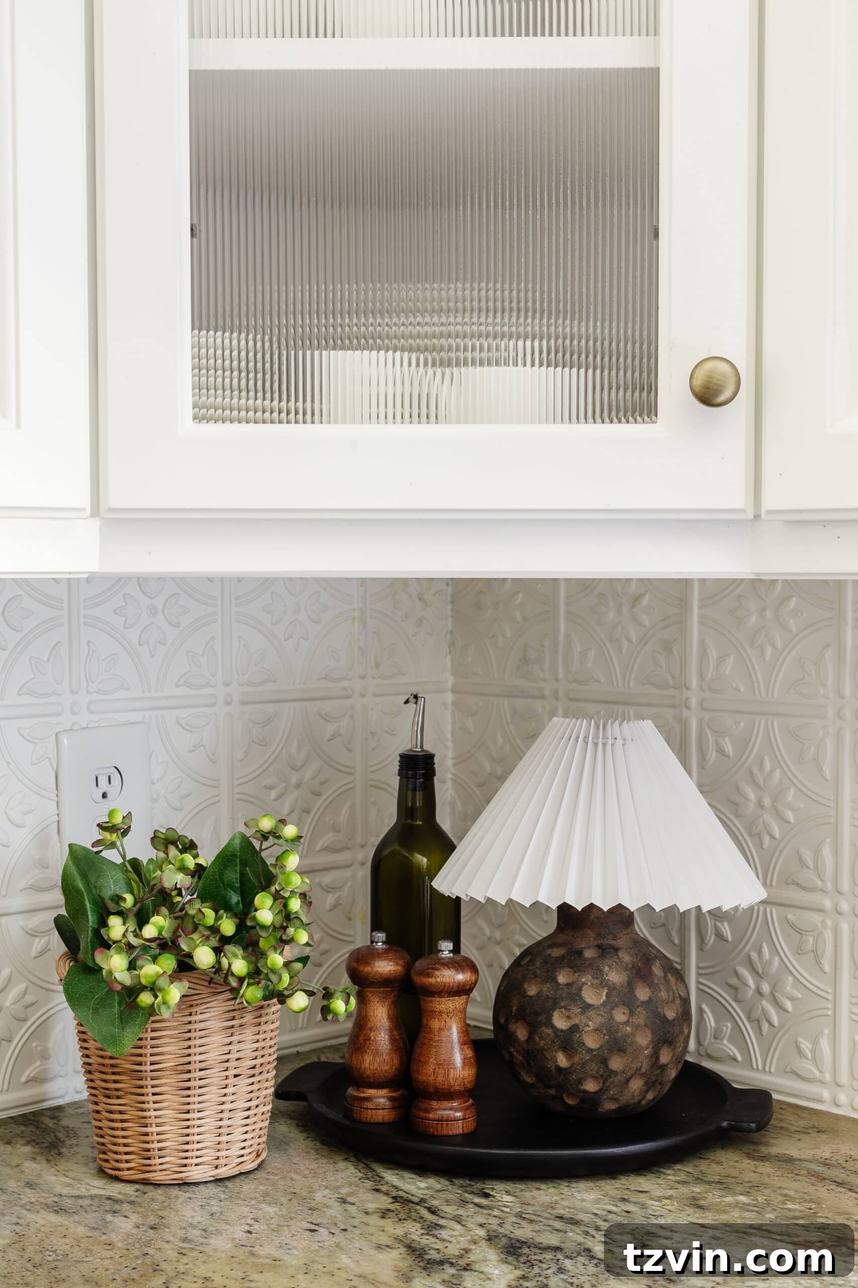 The final step: gently placing a pleated lamp shade, housing a battery light, onto the neck of a terracotta vase to create a complete cordless mini lamp.