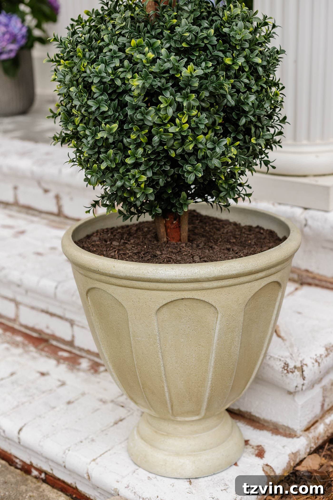 The Art of Creating Realistic Faux Trees 10 Artificial tree topiary planter expertly filled with dirt and recycled materials to look realistic and withstand outdoor weather