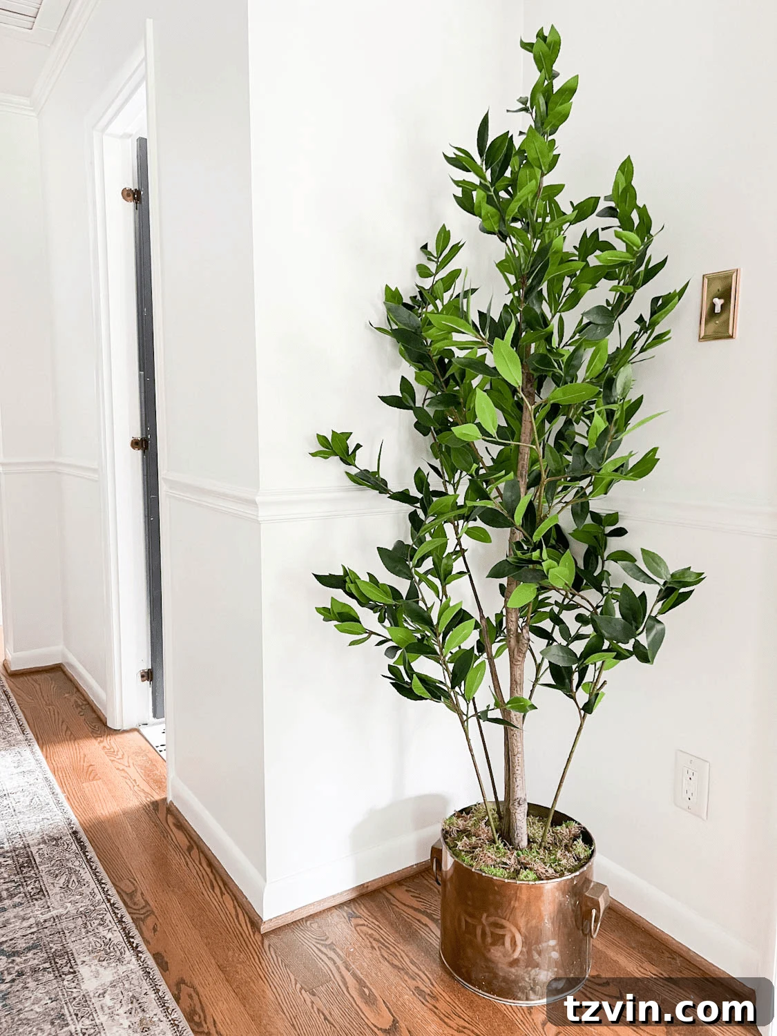 The Art of Creating Realistic Faux Trees 8 Vintage brass planter with a faux tree, now looking perfectly realistic after adding moss – displayed beautifully in a hallway setting