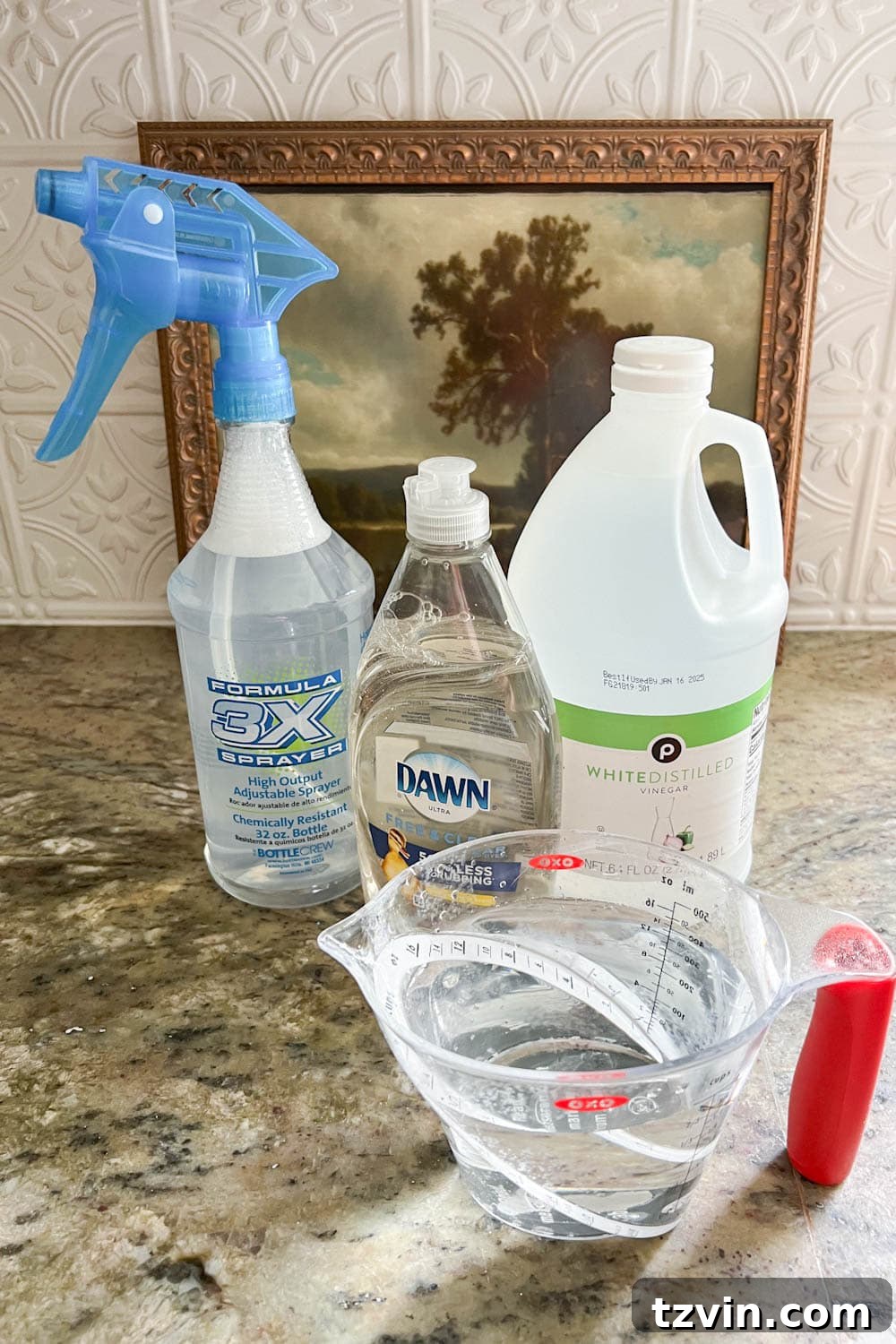 Preparing DIY couch cleaner solution using distilled water, white vinegar, and clear dish soap in a spray bottle.