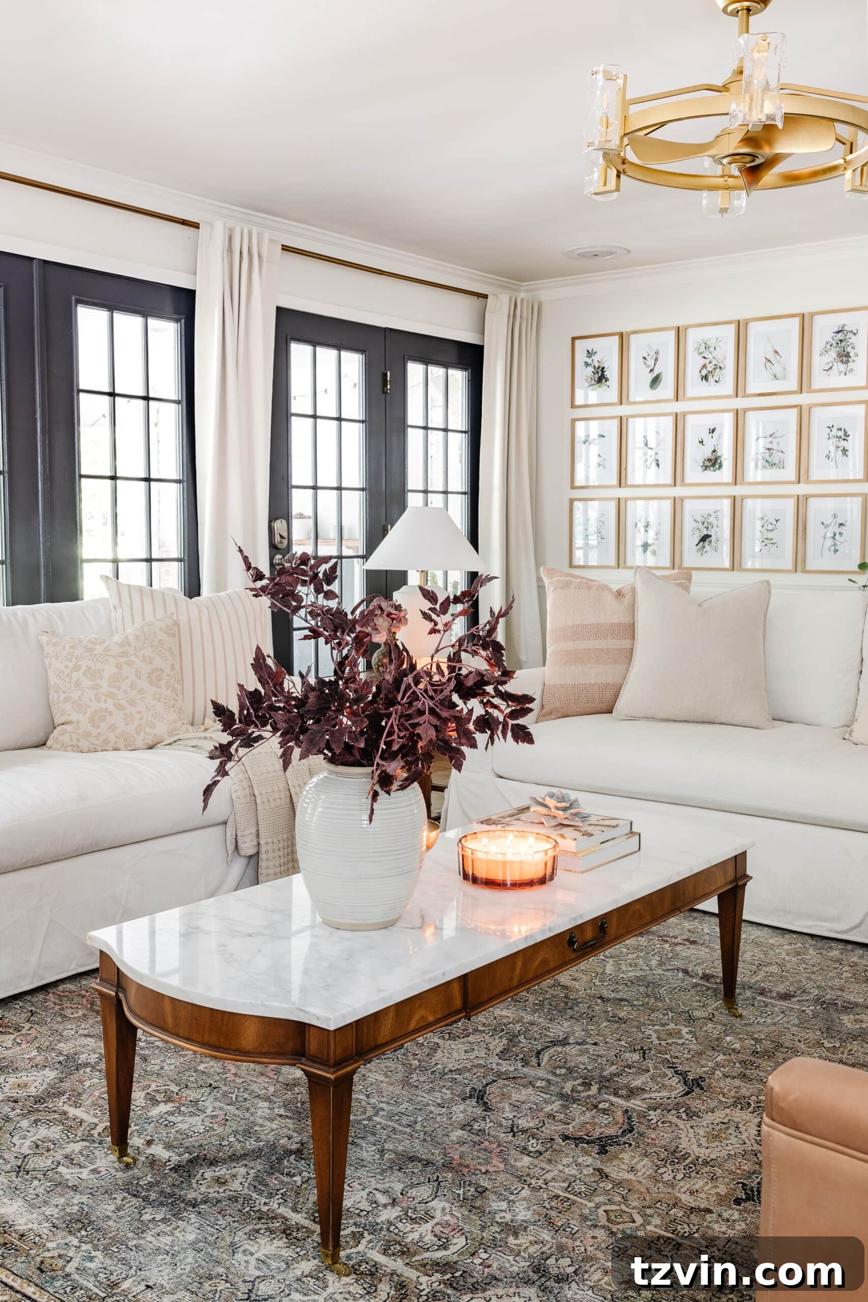 Effortless Autumn Living Room Decor for Less 7 Fall decor on a coffee table with vase of fall branches, candle, brass bowl, and books in front of white couches