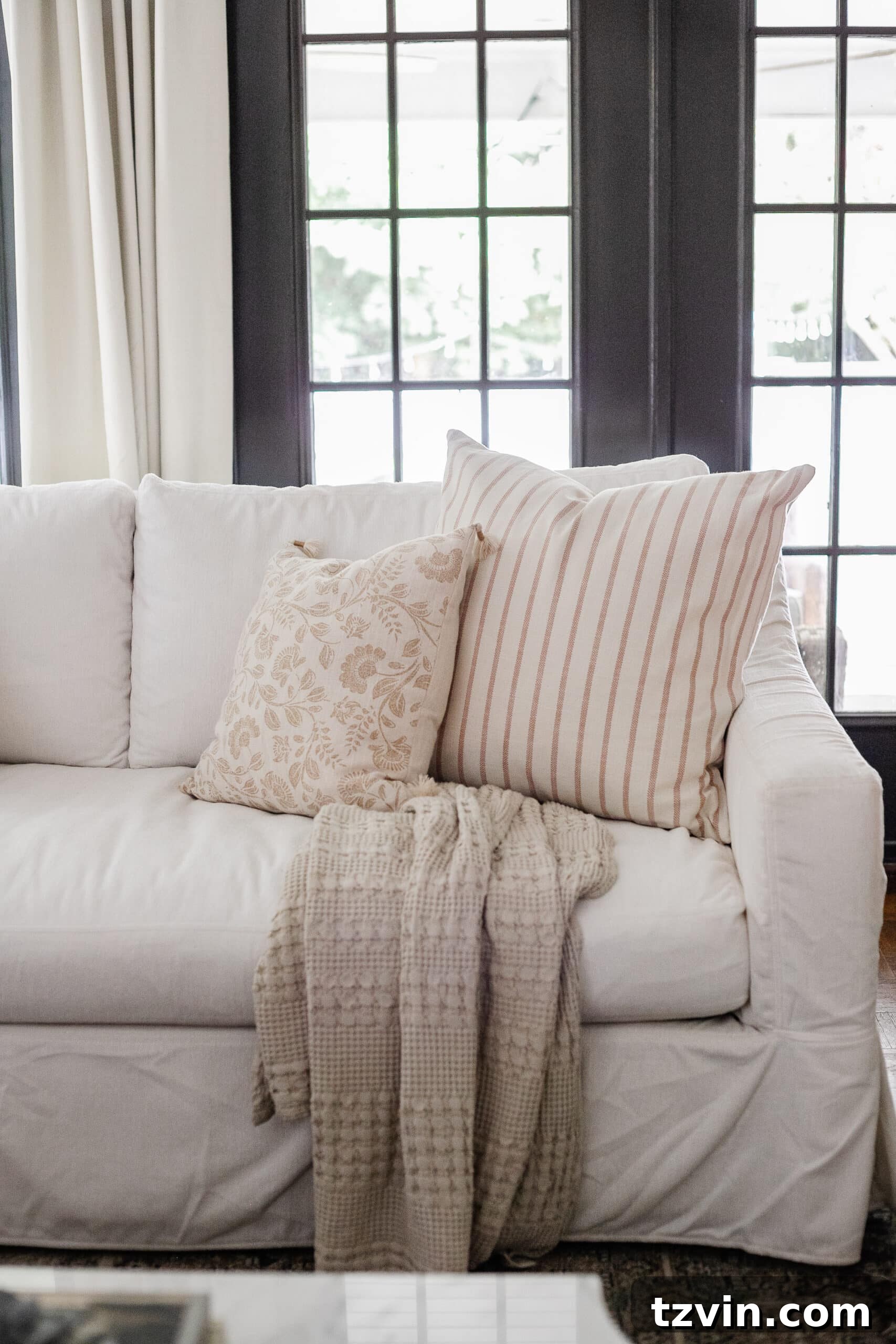 Effortless Autumn Living Room Decor for Less 10 Neutral fall pillows on a white couch in a living room decorated for fall