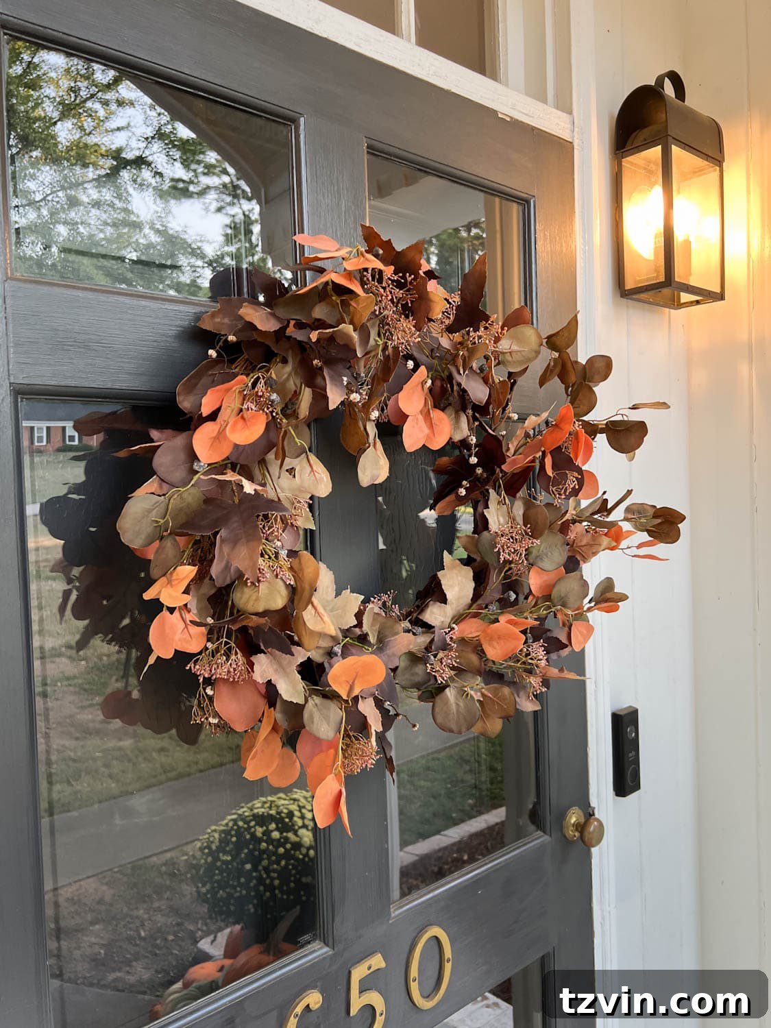 Harvesting Realism: The Top Fake Pumpkins of 2024 4 A close-up image of a beautifully fluffed artificial fall wreath adorning a front door, showcasing its realistic texture and vibrant autumn colors.