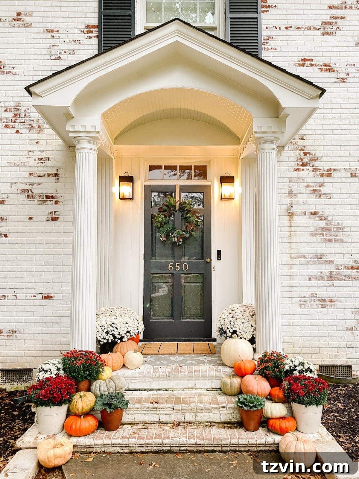 Harvesting Realism: The Top Fake Pumpkins of 2024 2 A charming fall porch decorated with an array of real heirloom pumpkins in various sizes and colors, complemented by vibrant fall-colored mums.