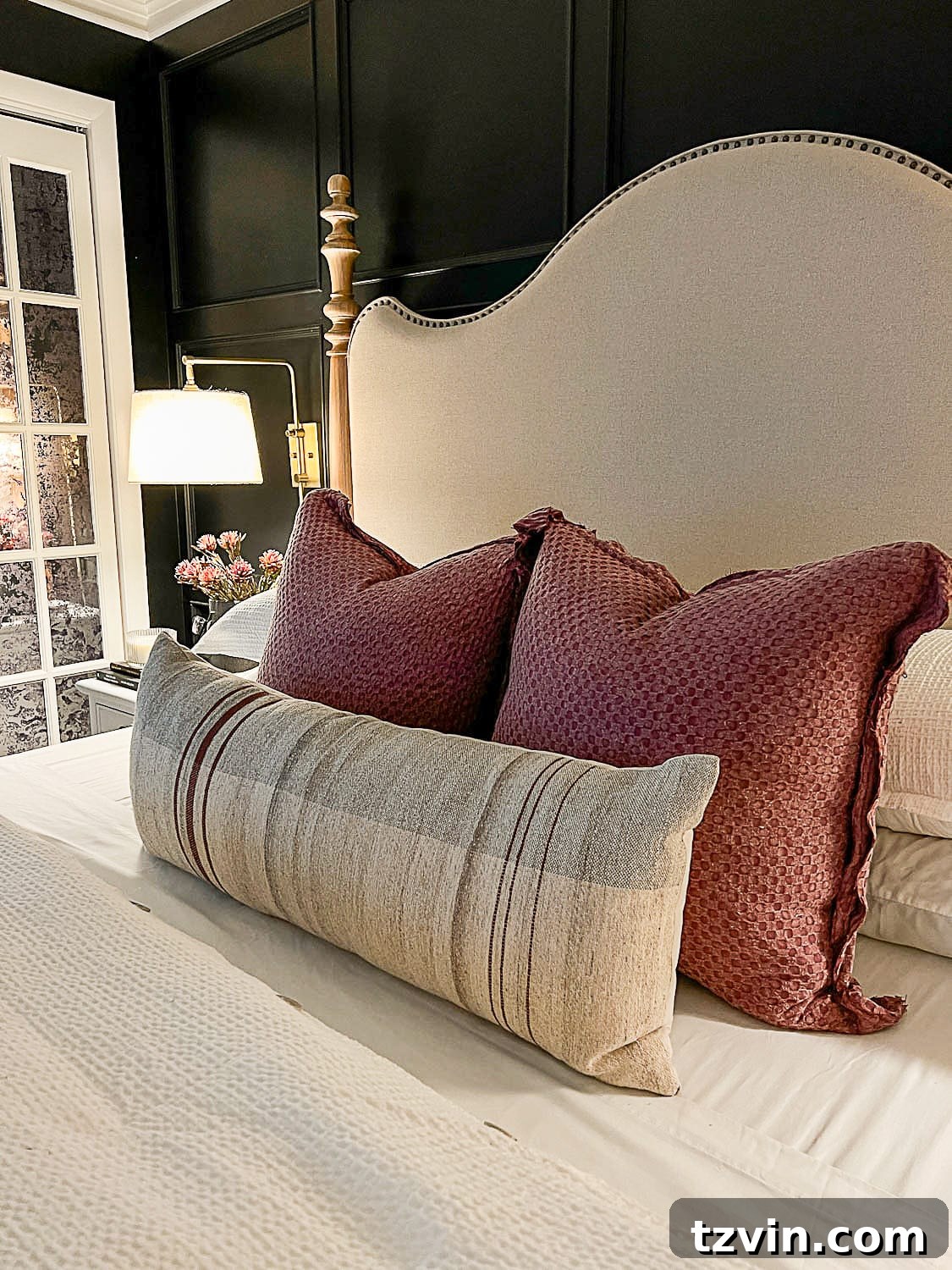 10 Budget-Friendly Ways to Create a Cozy Sleep Haven 9 fall pillows on bed with lamp light