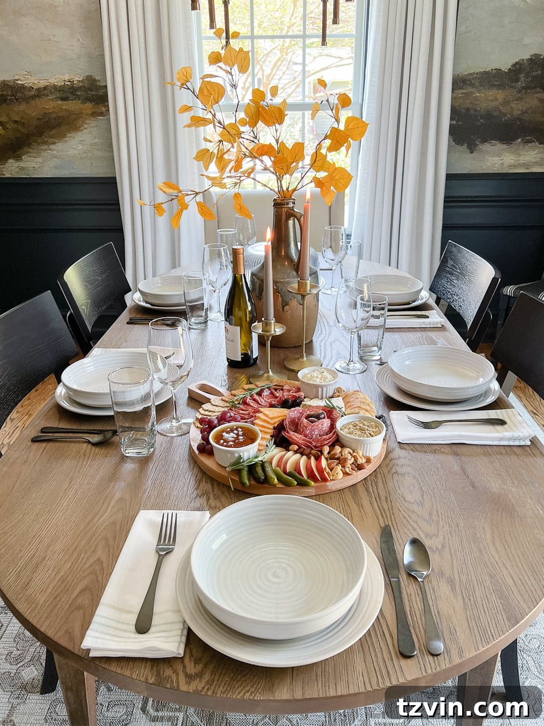 10-Minute Charcuterie Board Hack 11 A beautifully set dinner table with autumnal leaves in a vase and warm candlelight, creating a cozy and inviting ambiance.