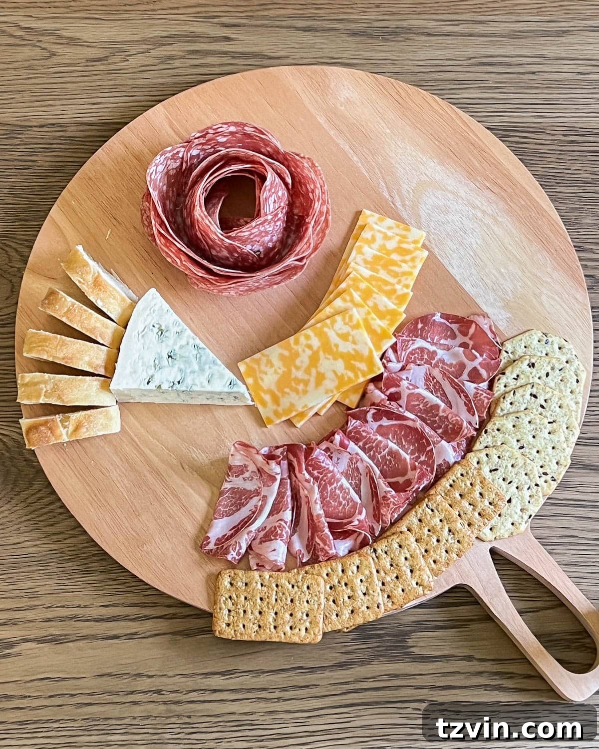 simple charcuterie board with crackers and bread added