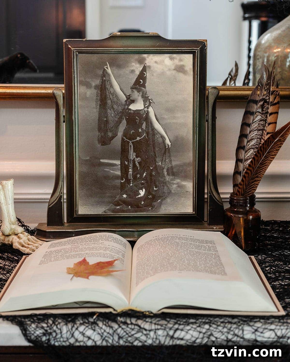 Hauntingly Chic: 30 Vintage Halloween Decor Must-Haves 5 vintage halloween portrait art in an antique picture frame with old book, ink well, and black fabric