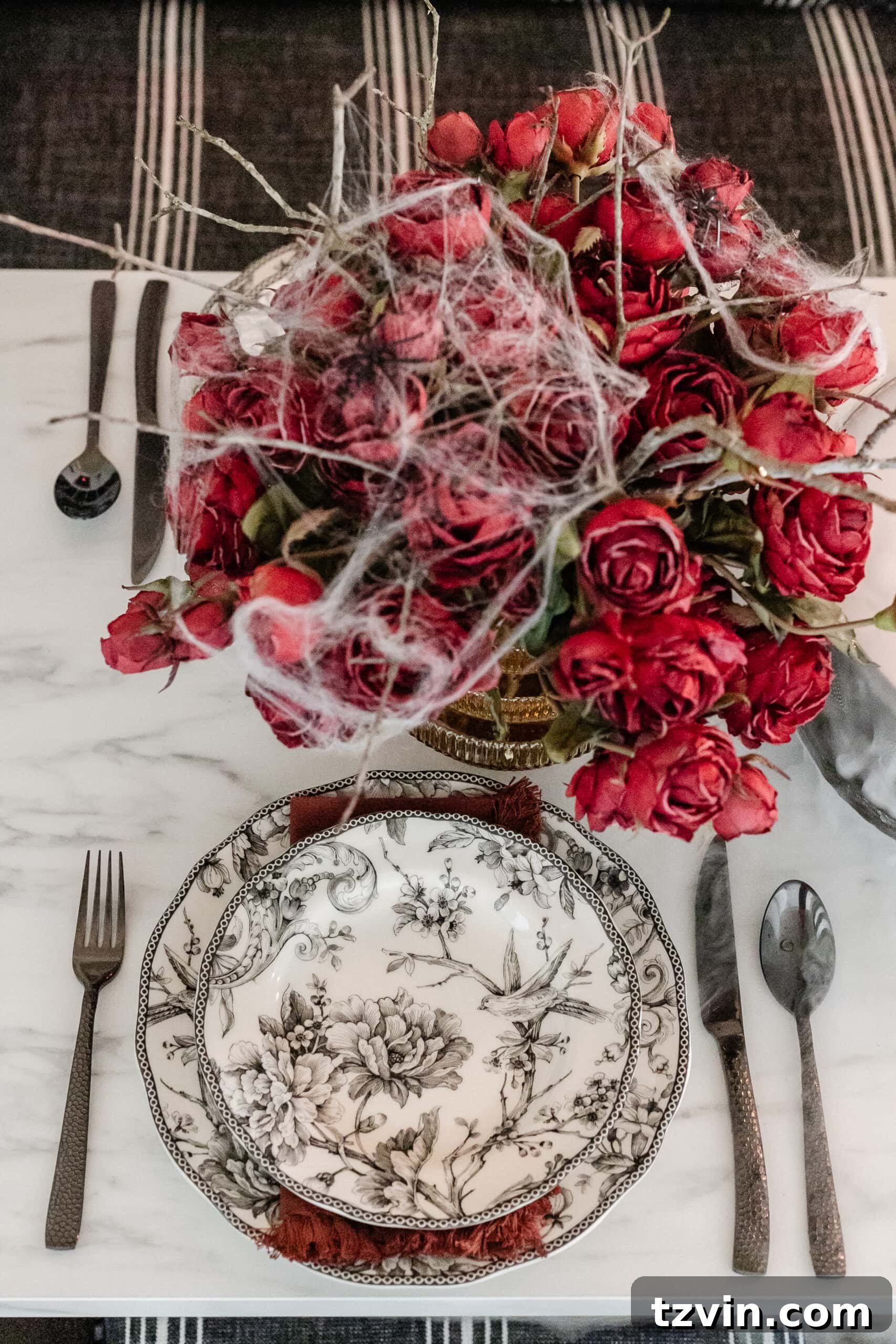 Killer Tablescapes: Spooky Settings for Your Murder Mystery Party 13 Black toile plates and hammered black flatware create an elegant Halloween place setting