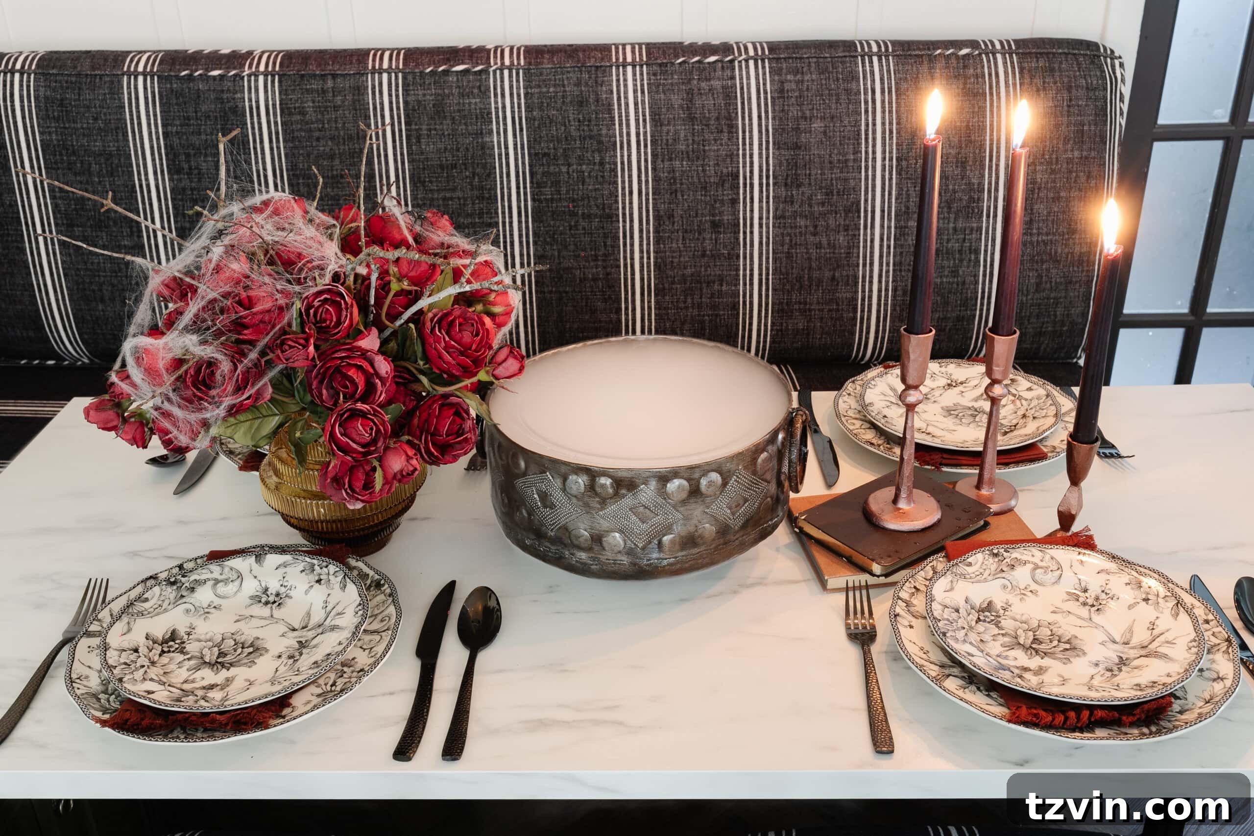 Killer Tablescapes: Spooky Settings for Your Murder Mystery Party 15 Halloween table decor featuring a bowl of dry ice fog, red roses with spider webs, and elegant black toile dinnerware
