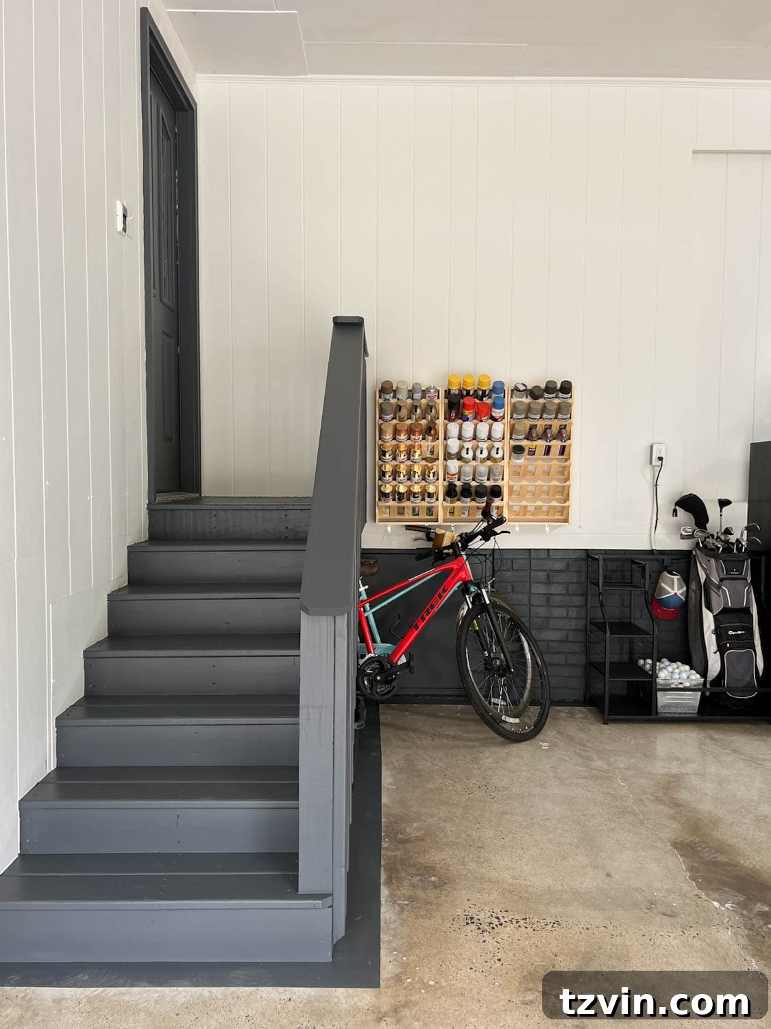 A section of the garage after the makeover, featuring organized paint can storage, sporting goods, and a clean overall appearance.
