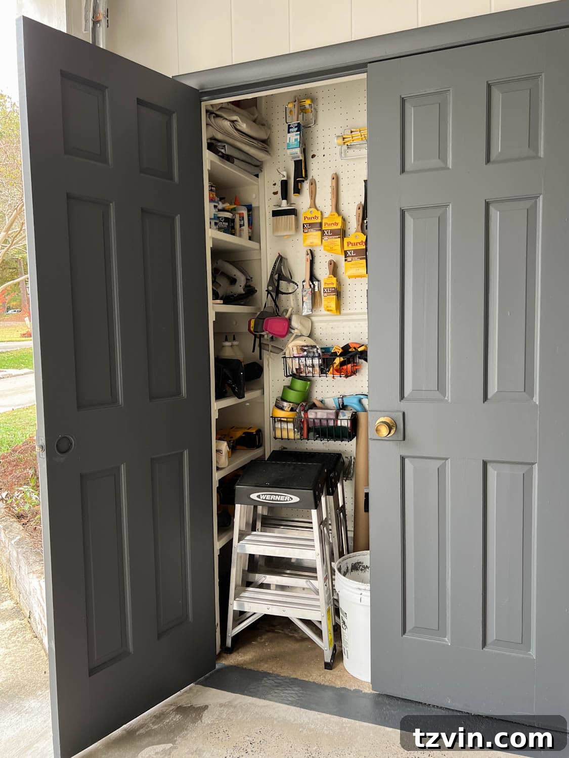 Interior of an organized paint storage closet utilizing pegboard and shelves for efficient storage of paint supplies.
