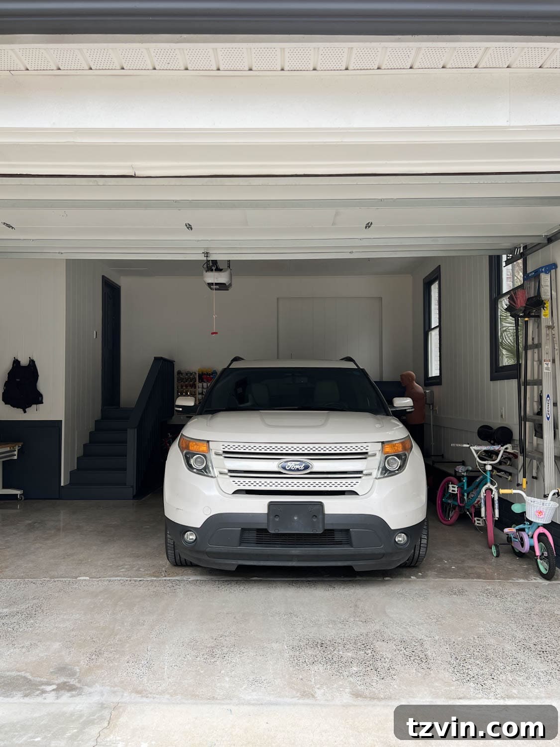 A car neatly parked inside a newly organized garage, showcasing the reclaimed space.