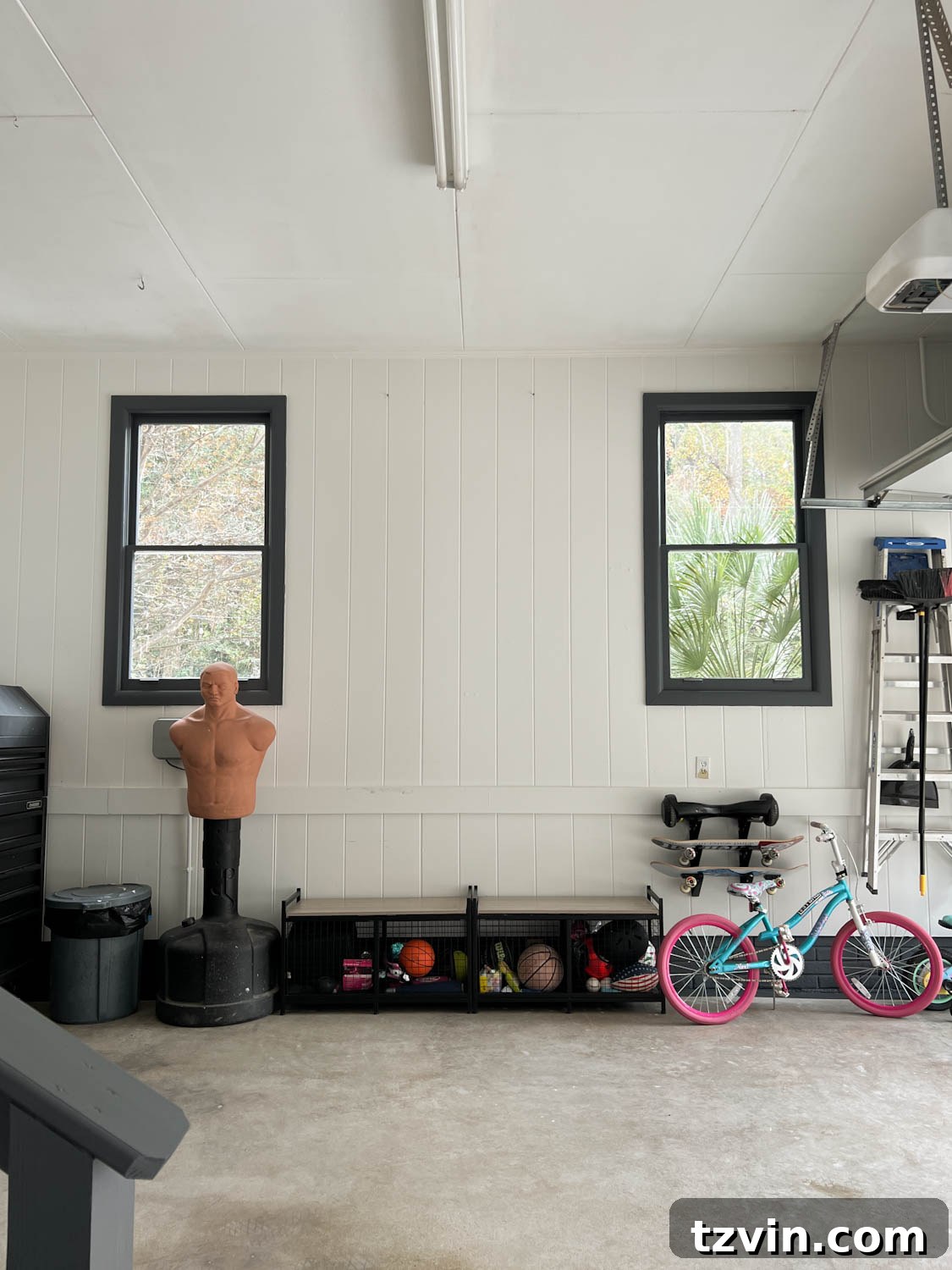 The garage after its makeover, featuring bright white walls and sleek black trim, creating a clean and spacious feel.